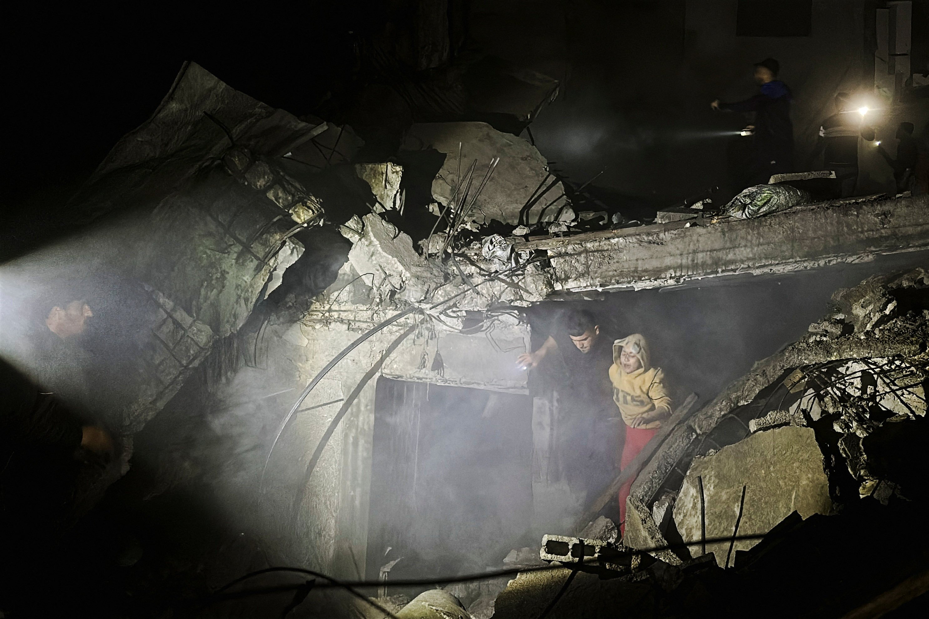 People make their way through rubble following an Israeli strike at a post office in Nuseirat in central Gaza Strip. Photo: Reuters