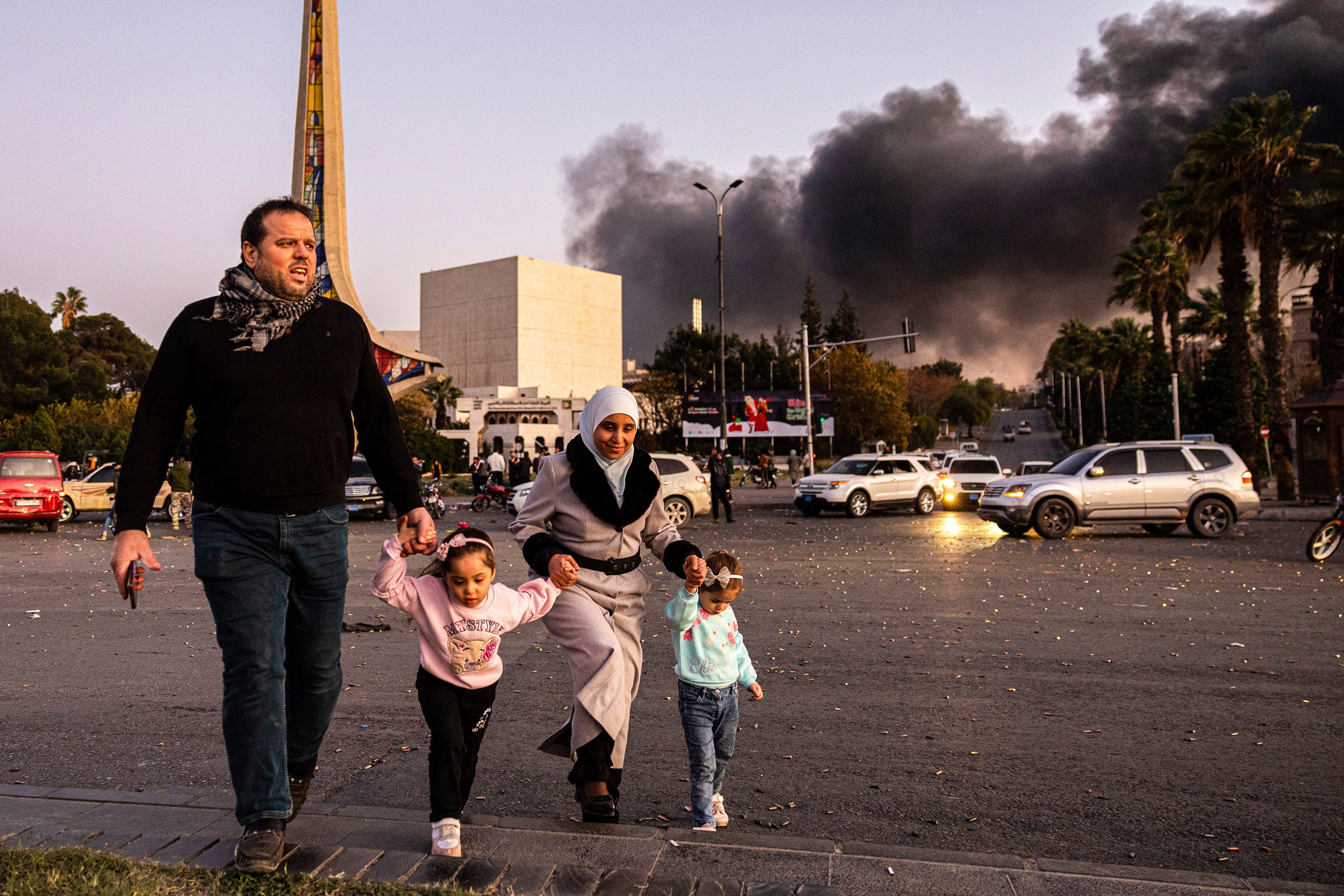 Smoke billows in the distance as people arrive to celebrate the overthrow of Bashar al-Assad, in Damascus, Syria, on December 8. Photo: AP