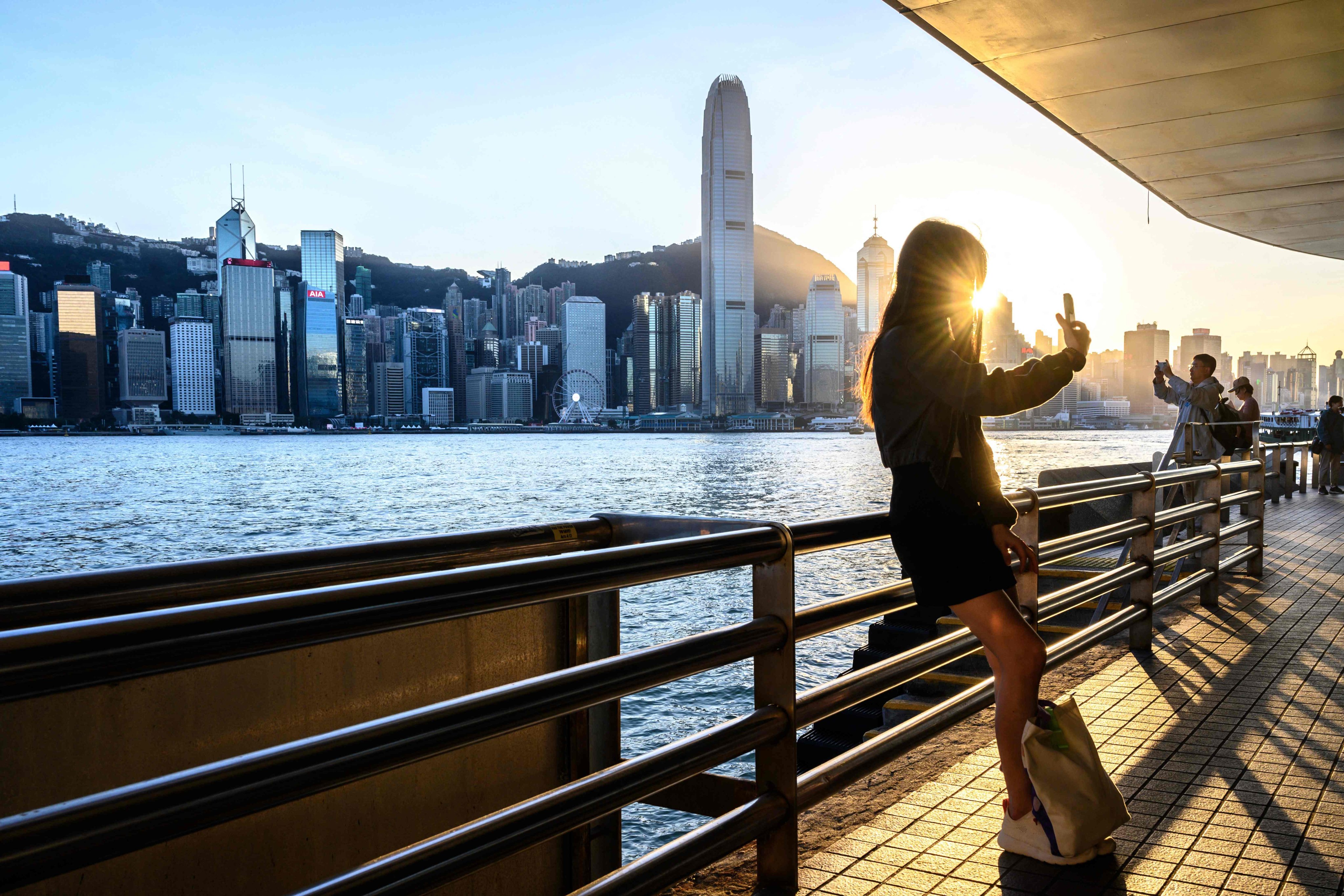 A woman takes a selfie at Victoria Harbour with the Hong Kong skyline as a backdrop. Photo: AFP