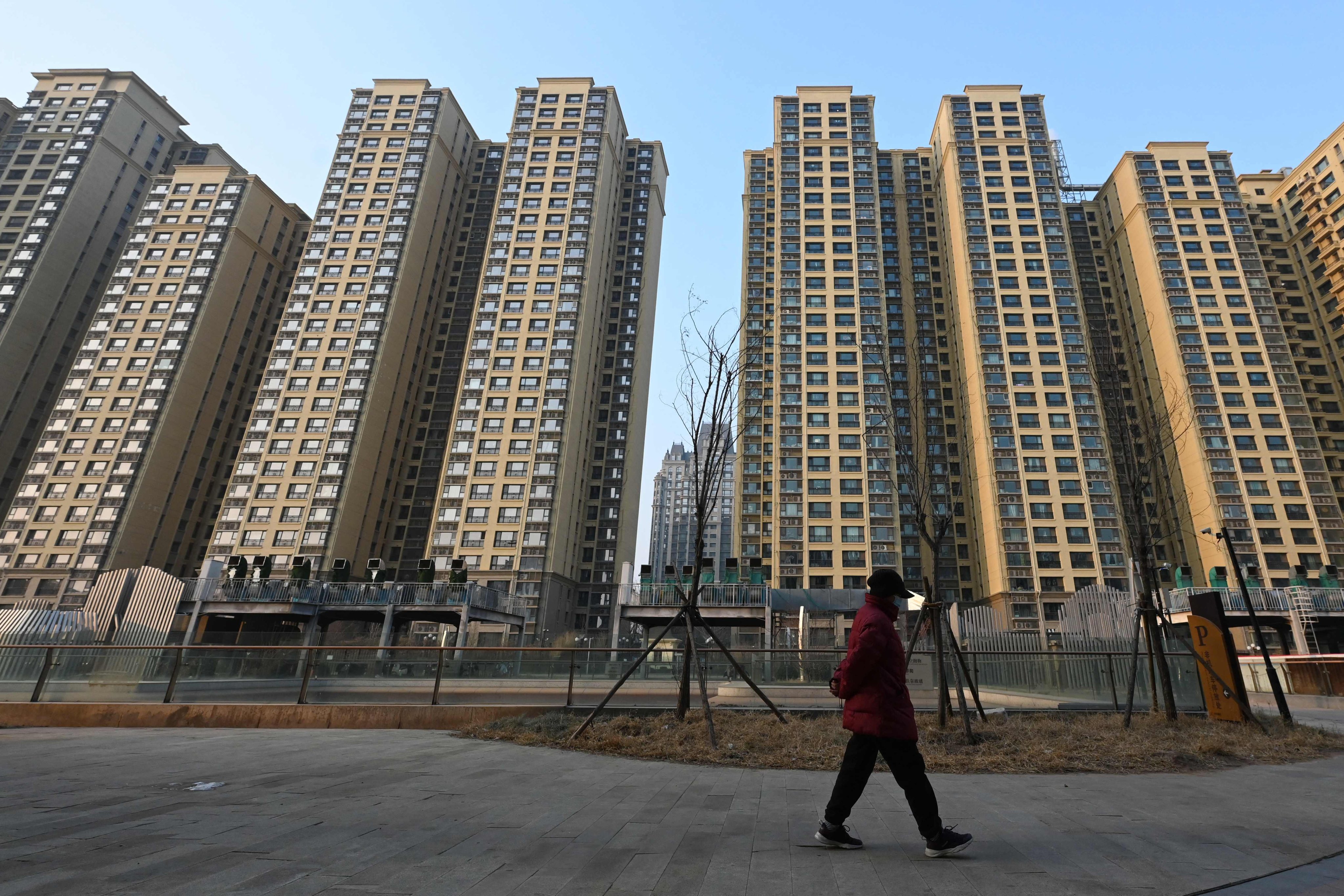  A woman walks past a residential complex in Beijing on January 29, 2024. Photo: AFP