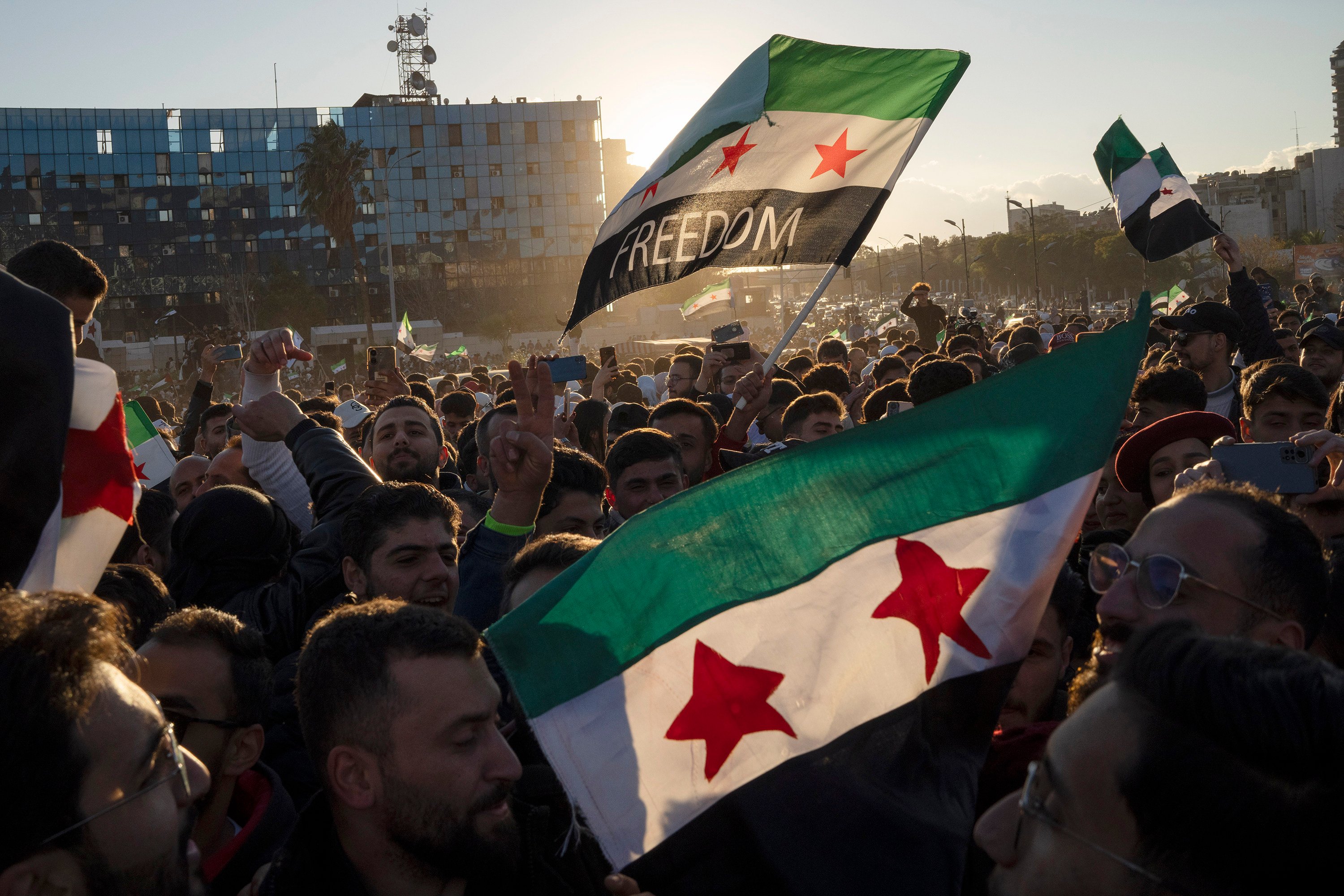 Syrians wave flags during a celebratory demonstration. Photo: AP