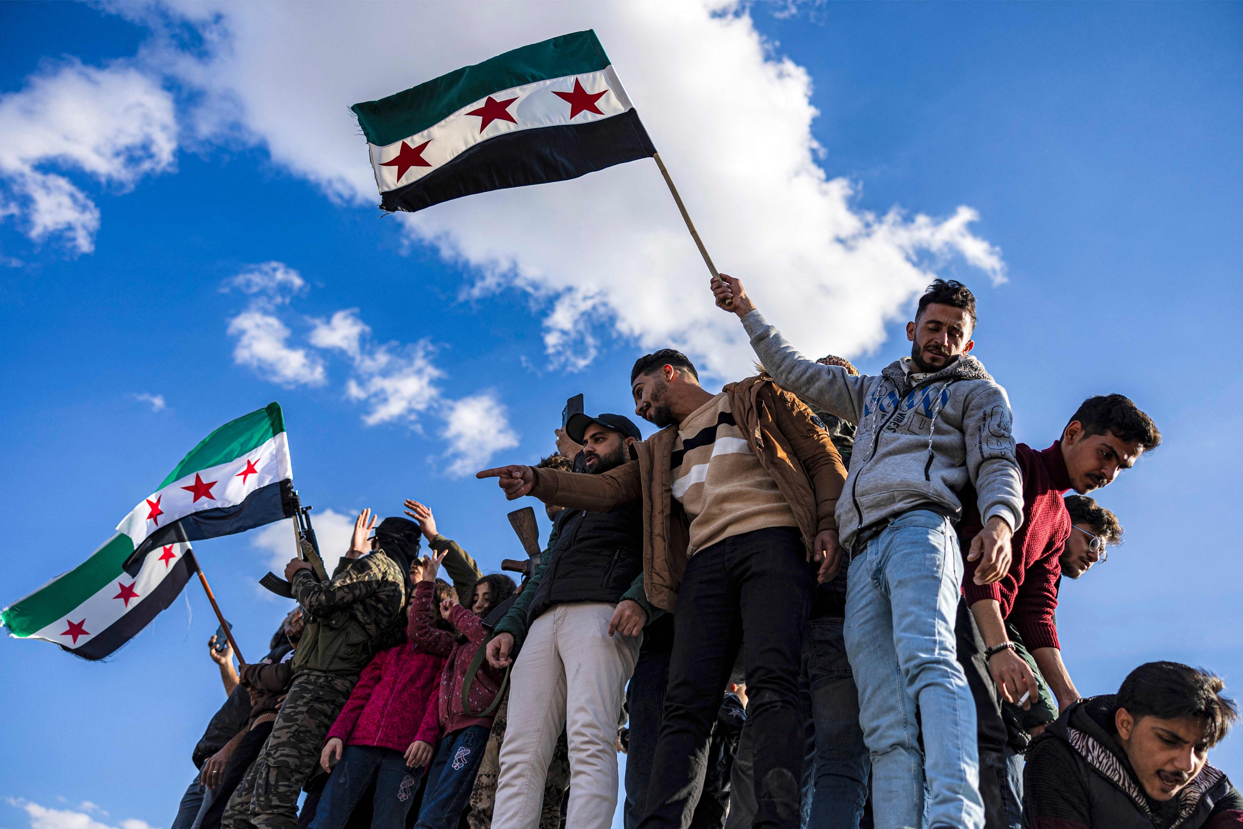 People gather with independence-era Syrian flags to celebrate the fall of Syria’s president Bashar al-Assad at the Umayyad Square in central Damascus on Friday. Photo: AFP