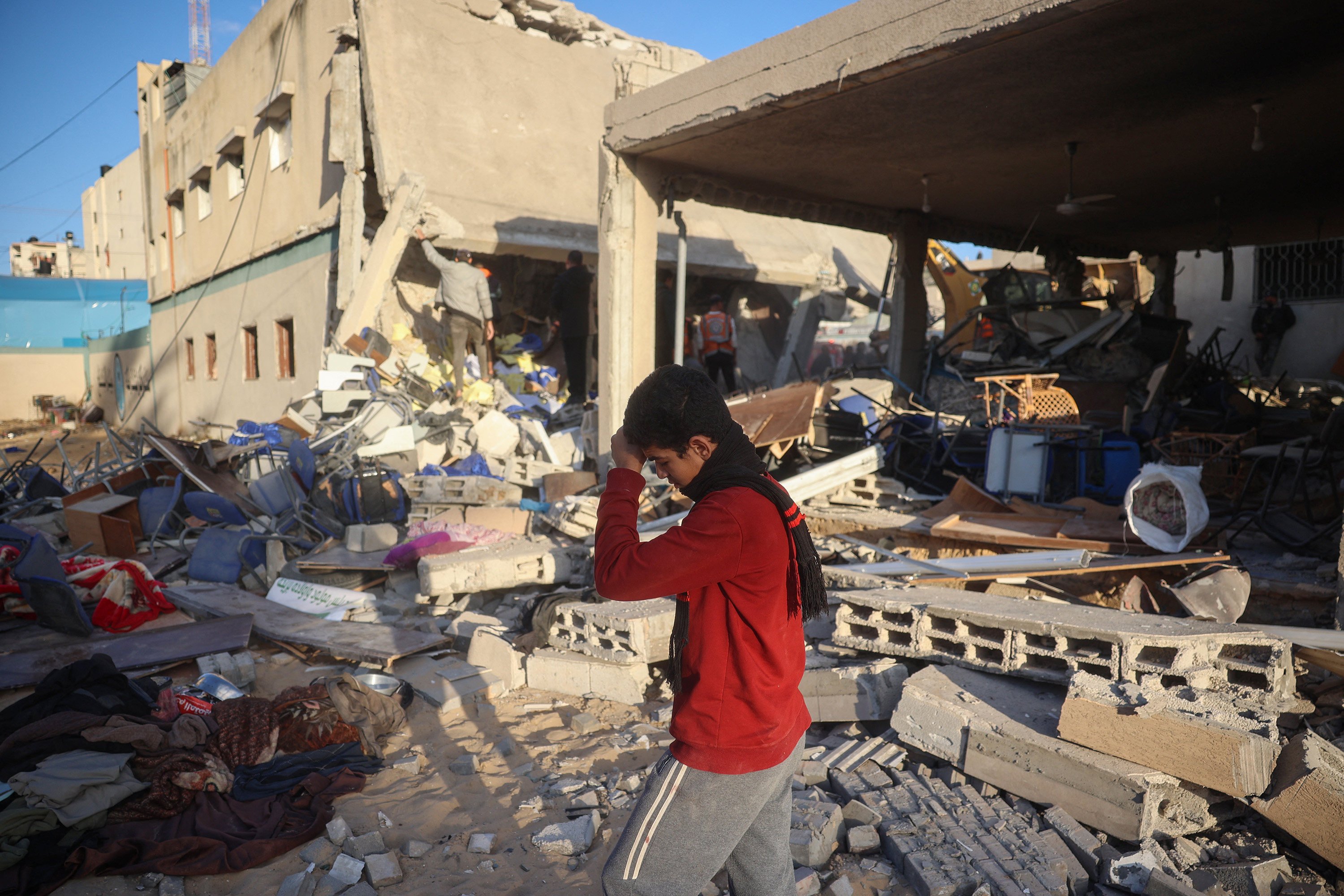 A boy walks on rubble as rescuers search for casualties following an Israeli strike on the municipality building in Deir el-Balah in the central Gaza Strip on December 14, 2024. Photo: AFP