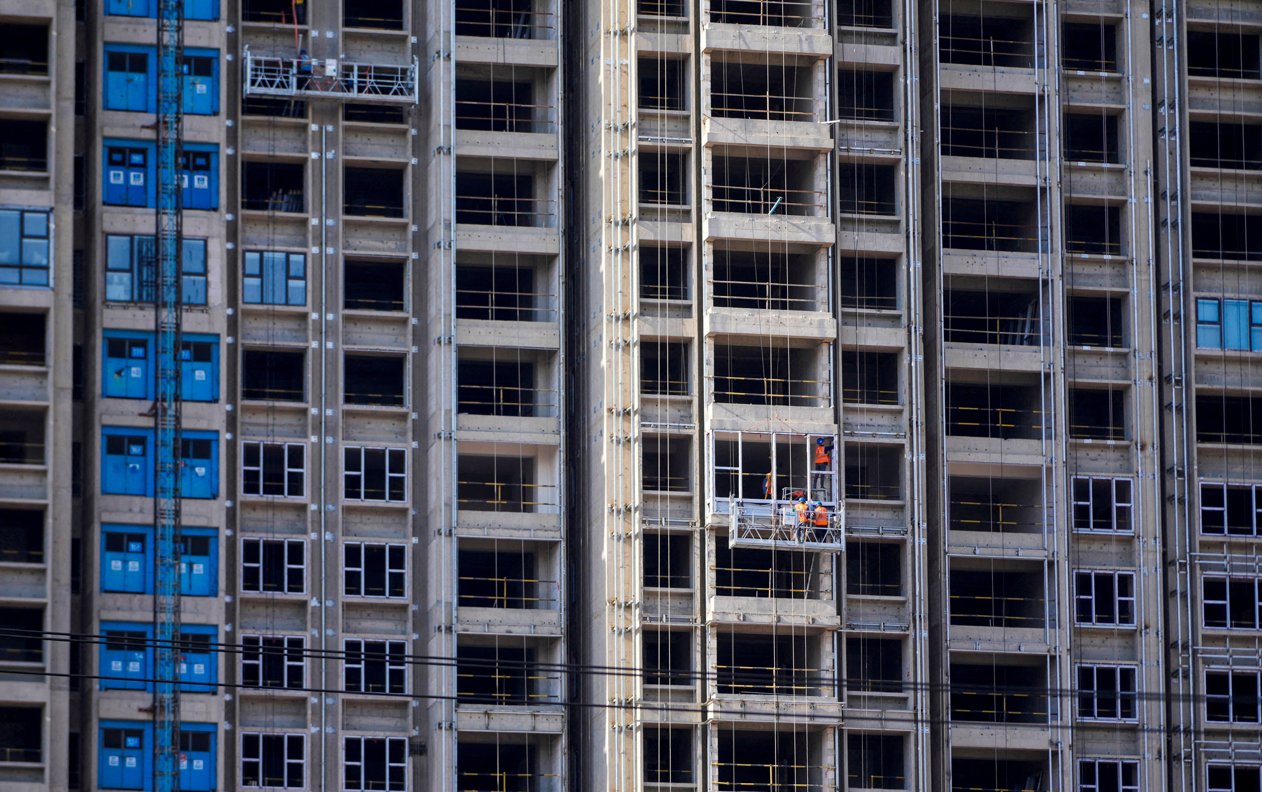 Workers install windows at a residential project in Shanghai. Photo: Reuters 