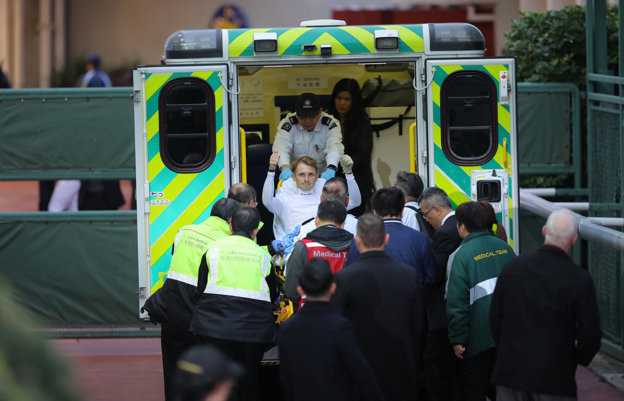 Lyle Hewitson gives the thumbs up as he is loaded into an ambulance at Sha Tin on Sunday.