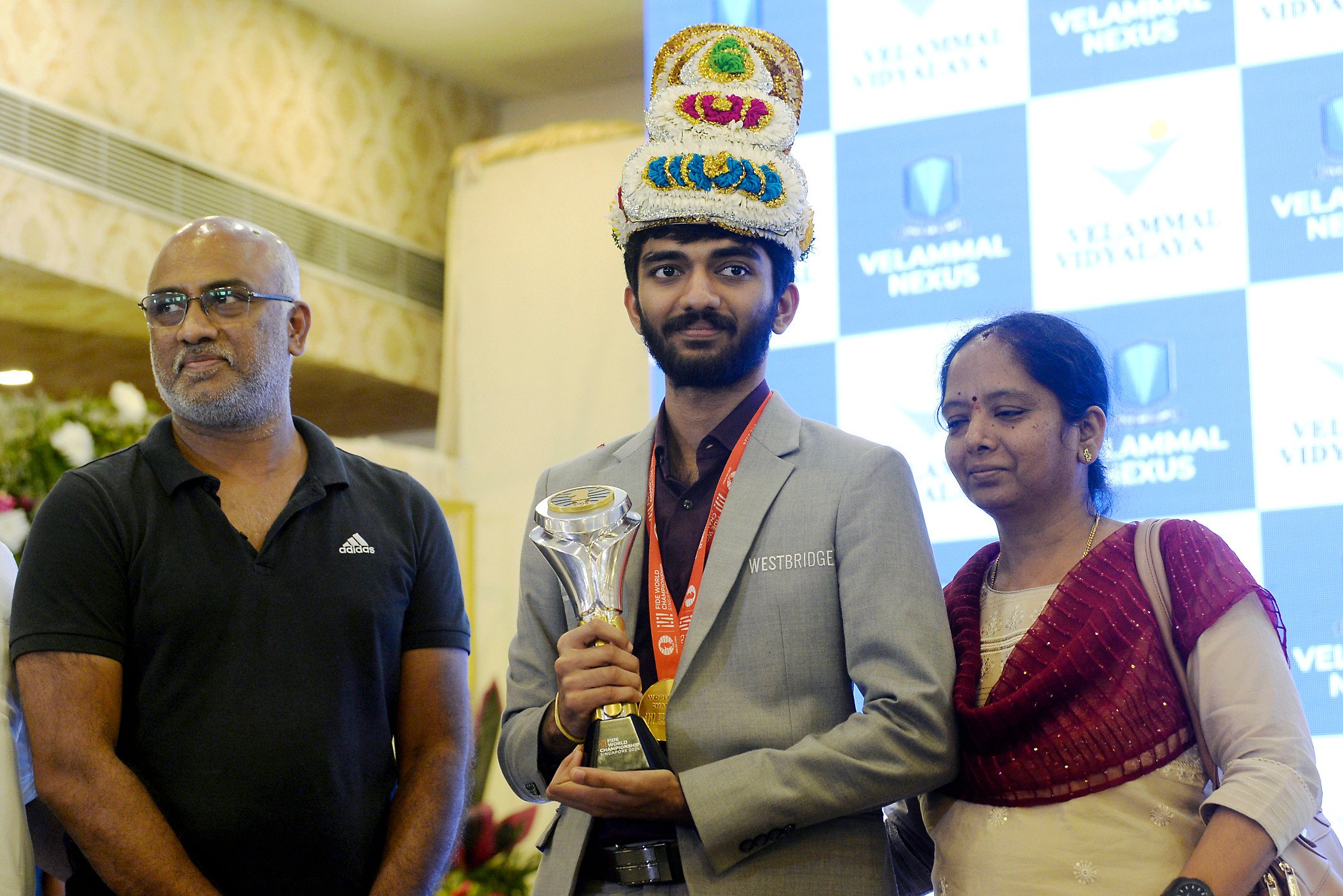 World chess champion Gukesh Dommaraju, his father Rajinikanth, and his mother Padmavathi at a ceremony in Chennai on his return from Singapore on Monday. Photo: AP