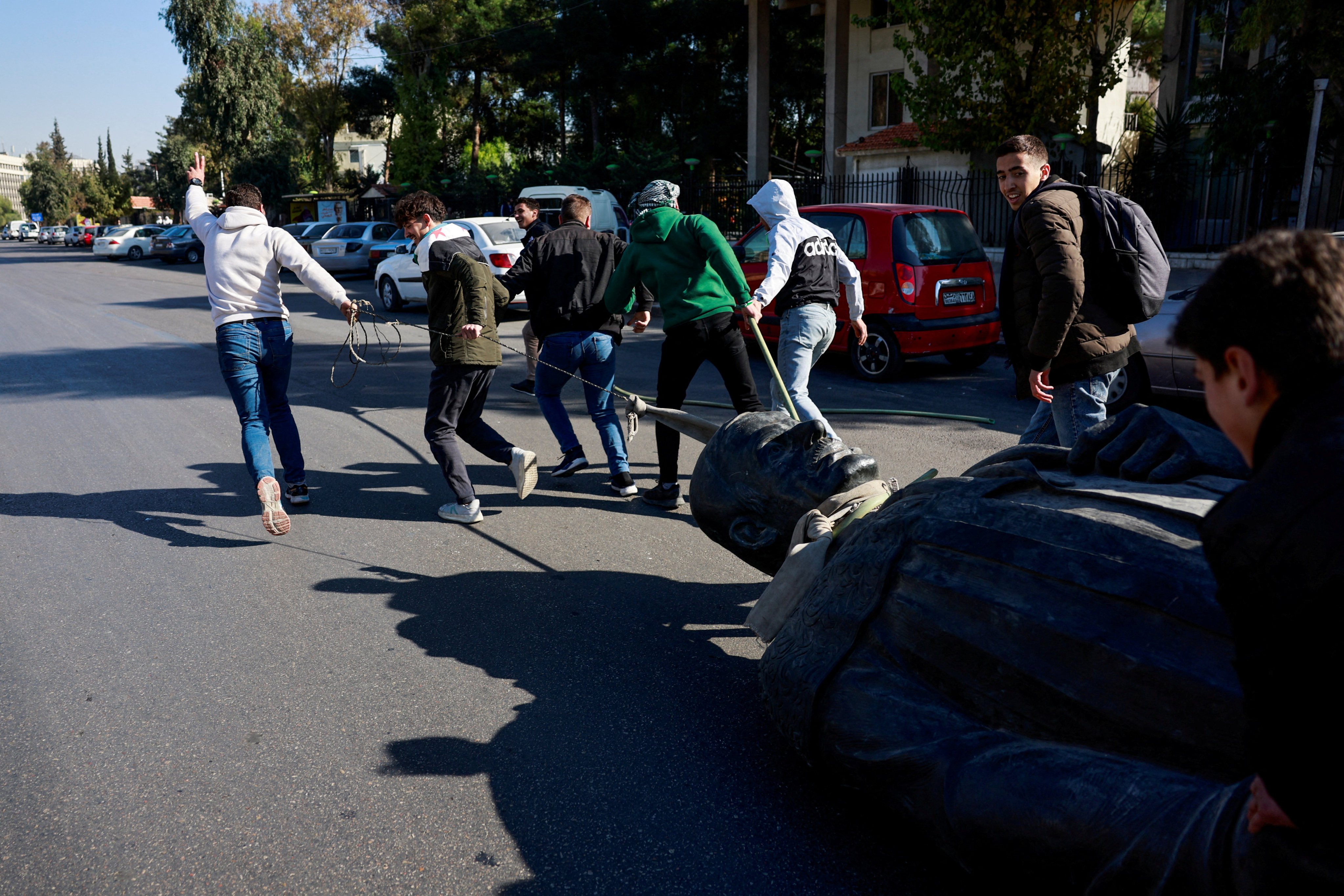 Damascus University students pull a toppled statue of the late Syria’s President Hafez al-Assad, father of Bashar al-Assad. Photo: Reuters