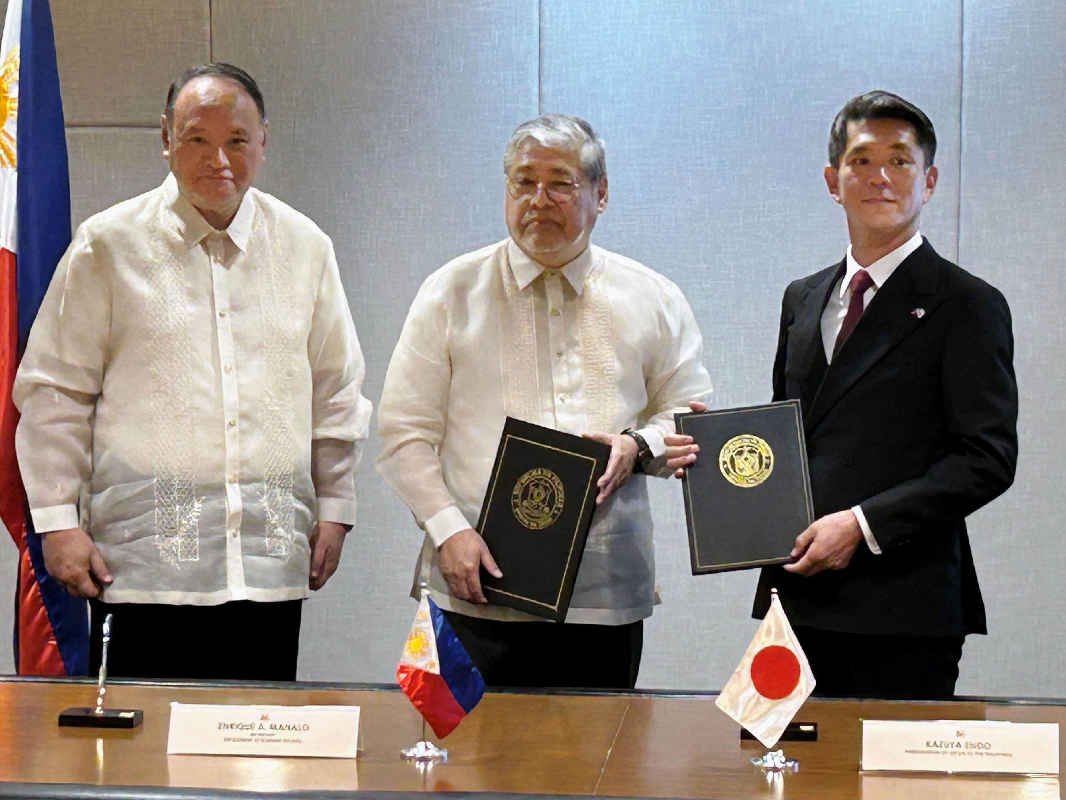 Philippine Defense Secretary Gilberto Teodoro (left) and Foreign Secretary Enrique Manalo (centre) pose with Japanese Ambassador to the Philippines Kazuya Endo in Manila on December 5, after the countries signed an agreement for Japan to provide coastal surveillance radar to Manila. Photo: Kyodo