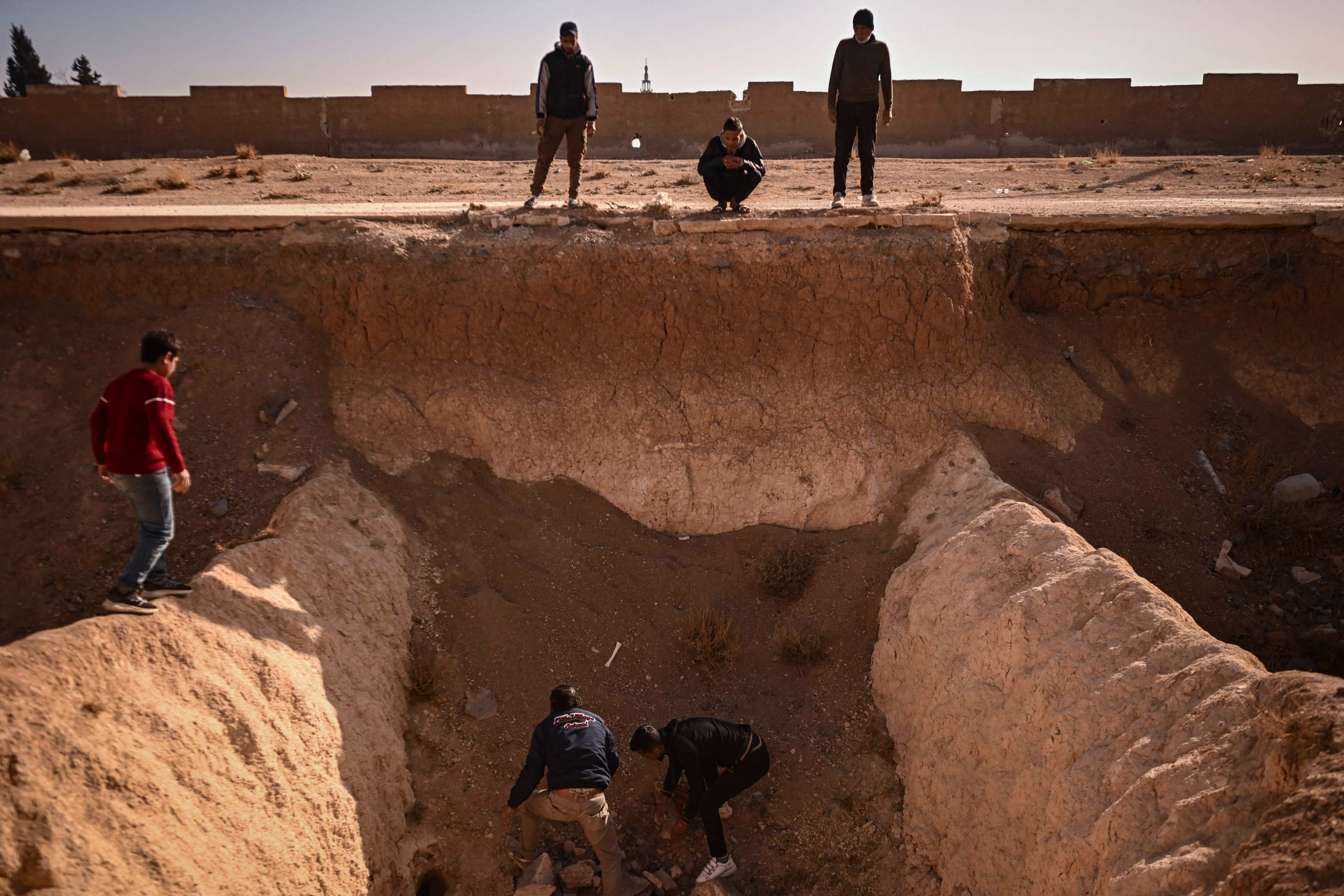 People search for human remains at a trench believed to be used as a mass grave on the outskirts of Damascus. Photo: AFP