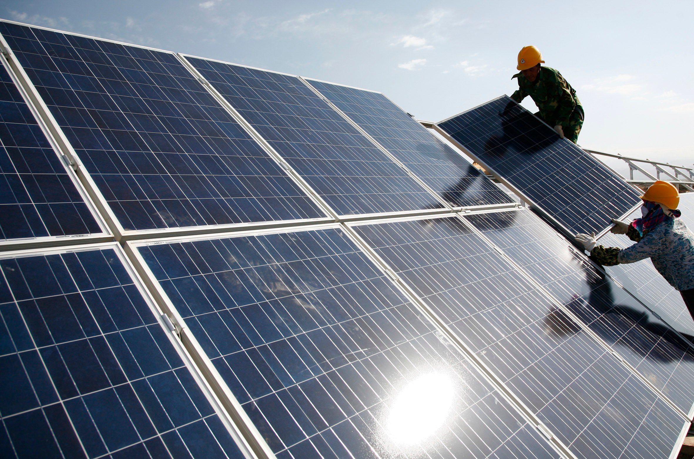 Workers installed solar panels at a power station in the Xinjiang Uygur Autonomous Region. Photo: Chinatopix via AP 