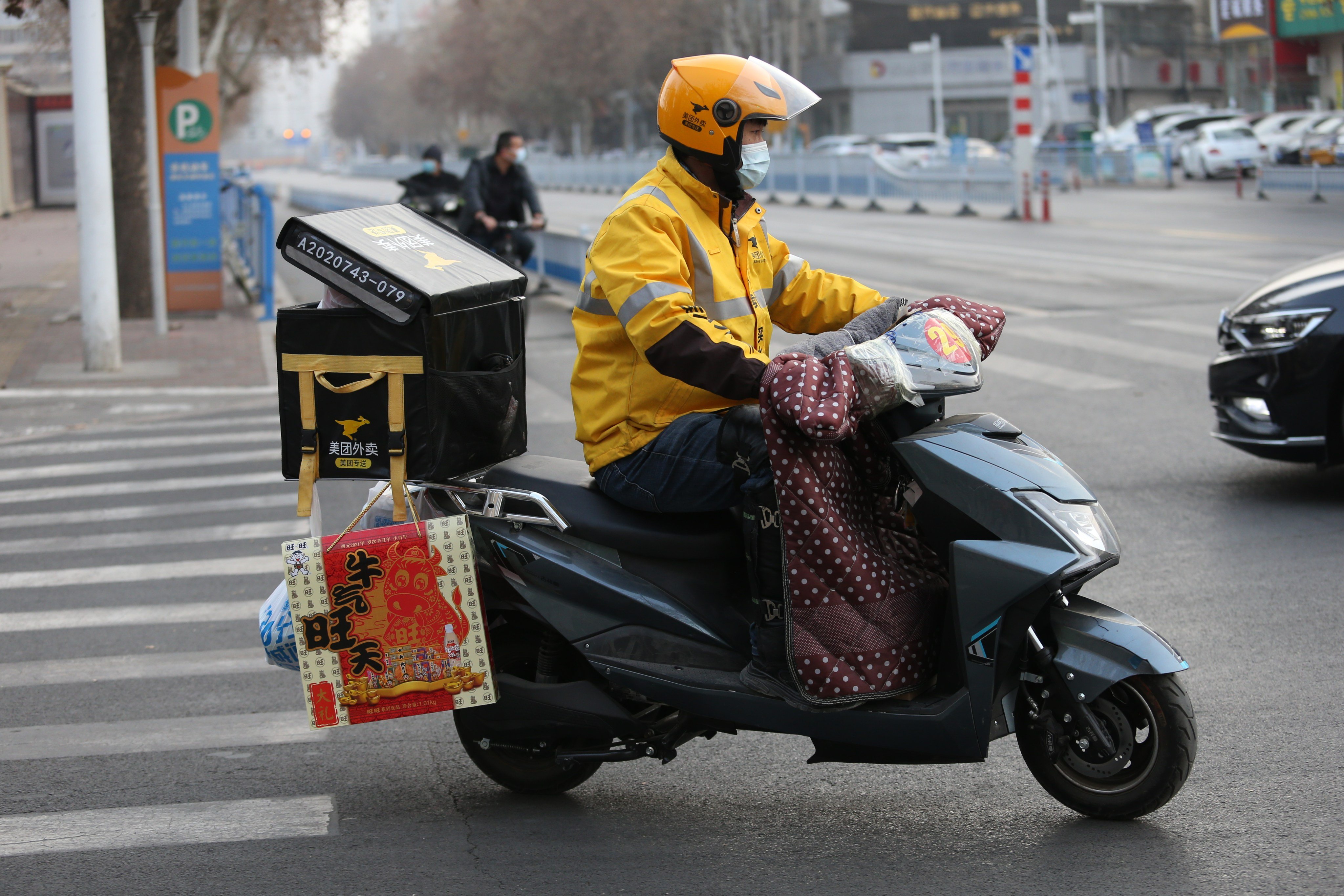 A Meituan food courier rides an electric bike along a street during a lockdown in Shijiazhuang, Hebei province, on January 15, 2021. Photo: VCG via Getty Images