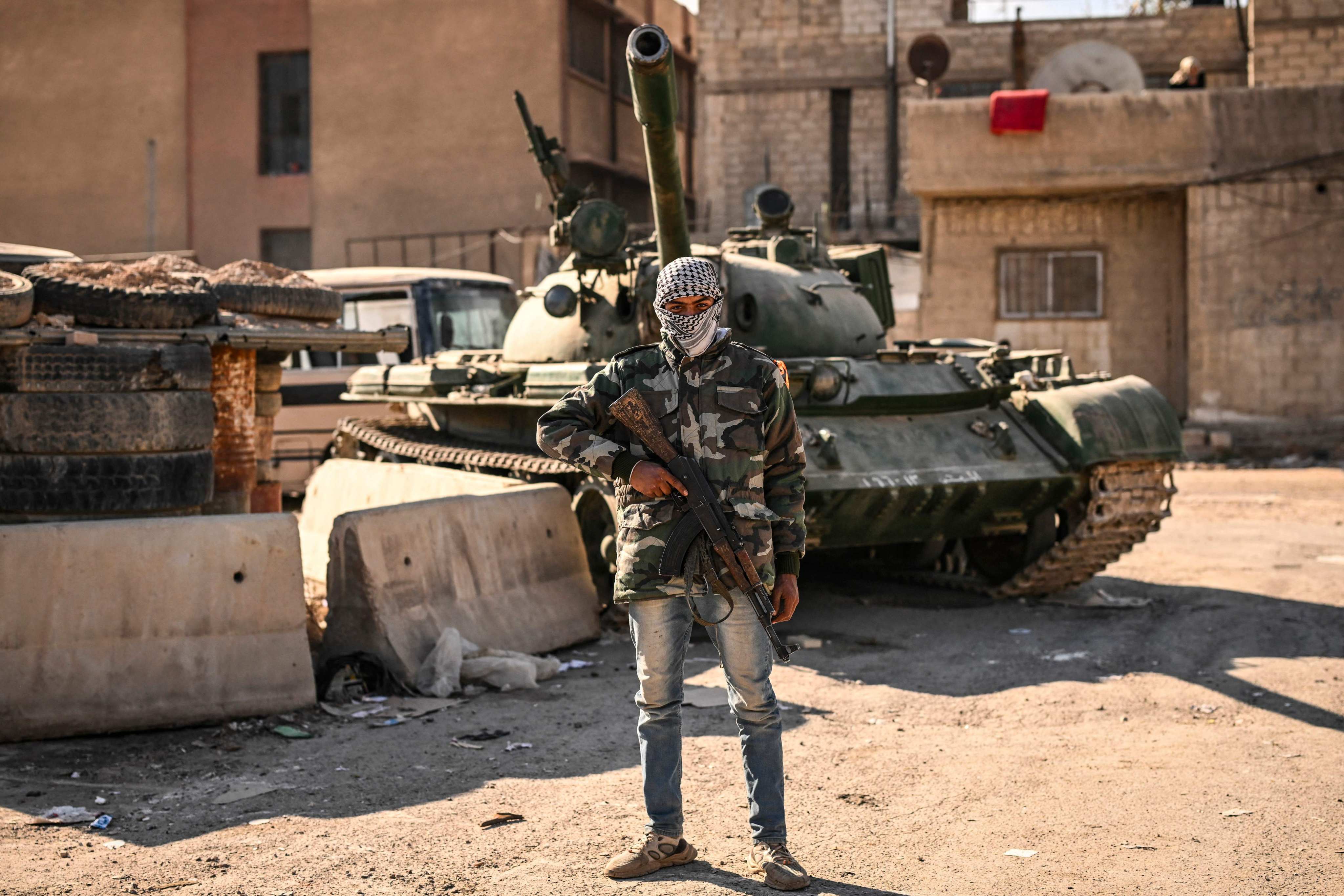 A rebel fighter poses in front of an abandoned tank in the town of Adra on the northeast outskirts of Damascus. Photo: AFP