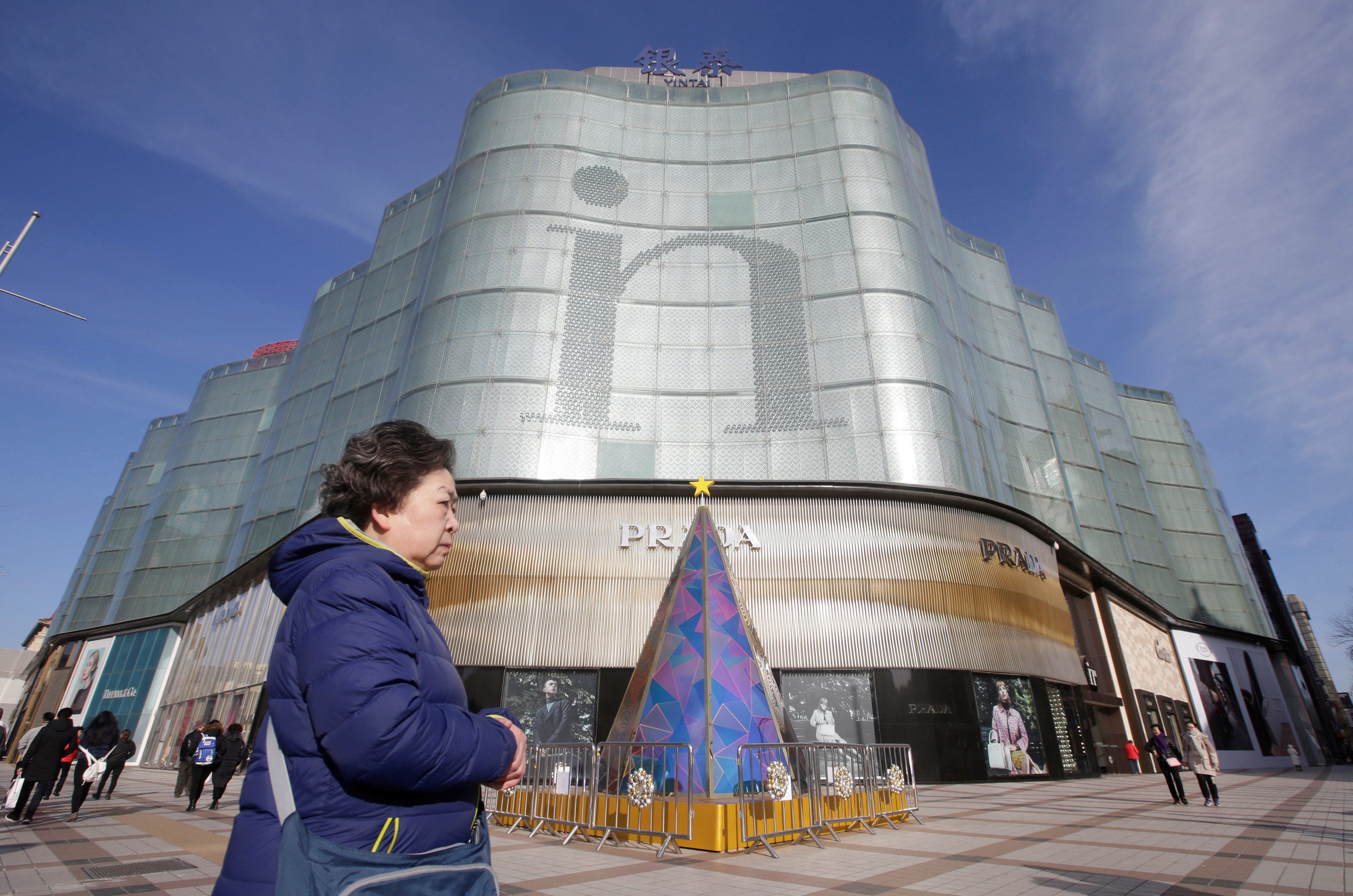 A woman walks past an Intime Lotte shopping centre in downtown Beijing on January 10, 2017. Photo: Reuters