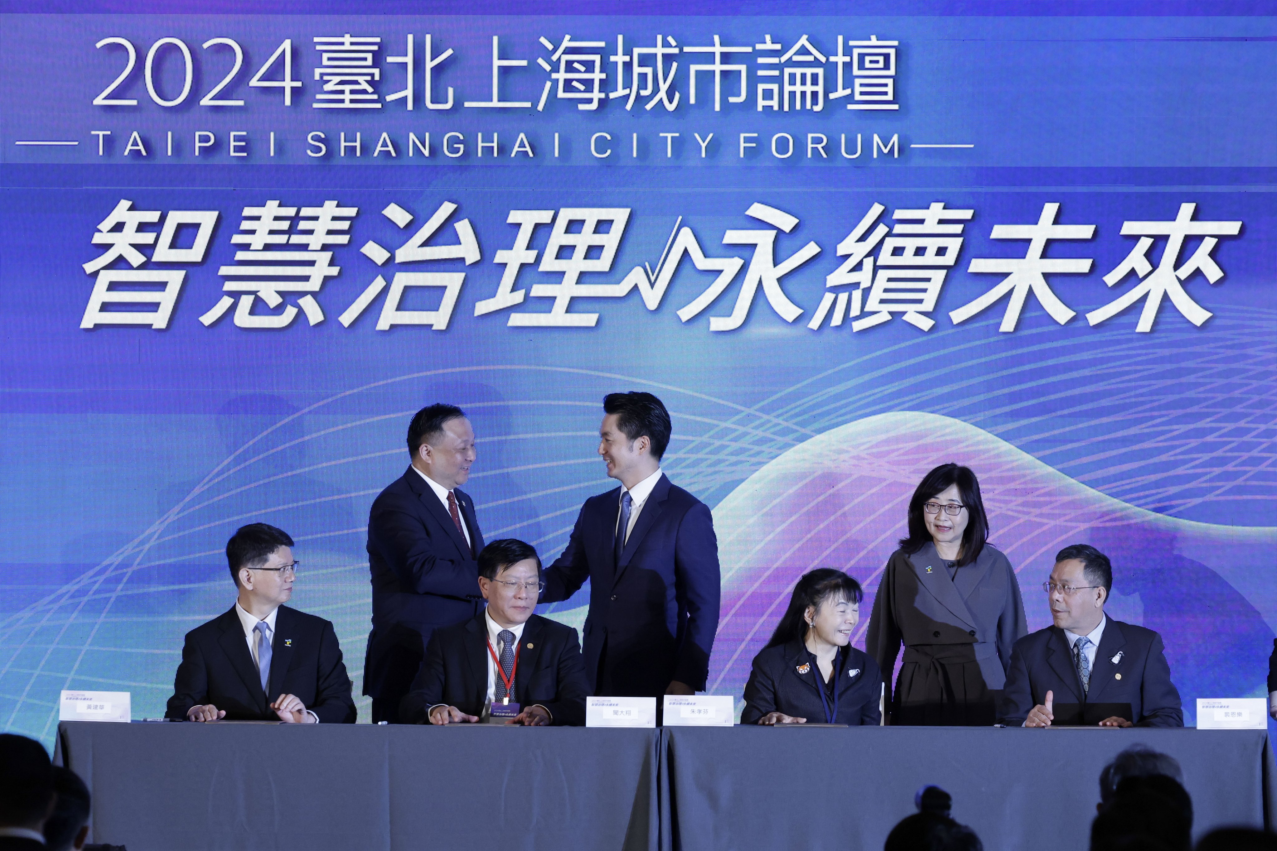 Shanghai vice-mayor Hua Yuan (back left) and Taipei mayor Wayne Chiang Wan-an (back right) shake hands after signing a memorandum of understanding at the forum in Taipei on Tuesday. Photo: EPA-EFE