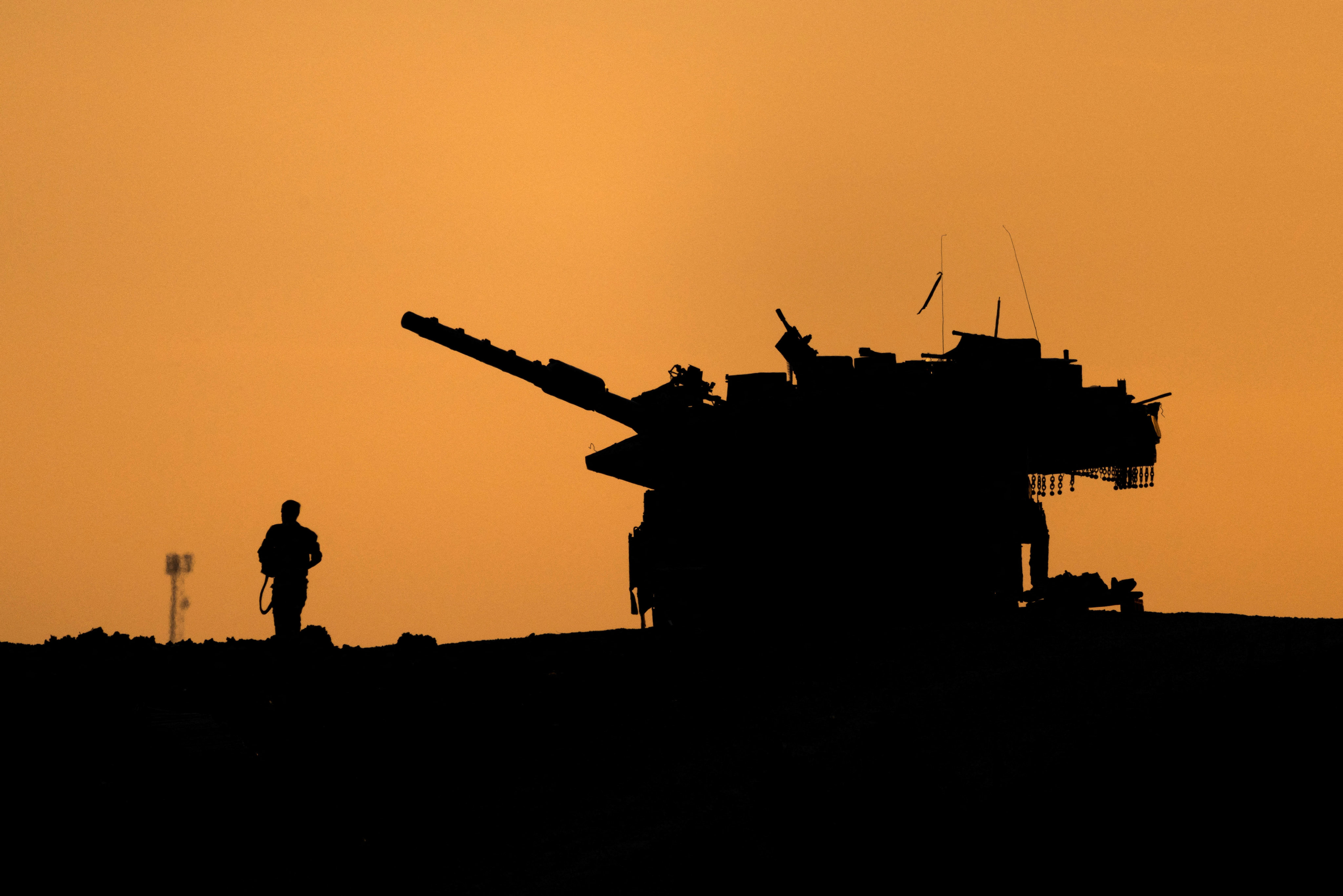 The silhouettes of a military vehicle and a soldier are seen near the Gaza border. Photo: Reuters