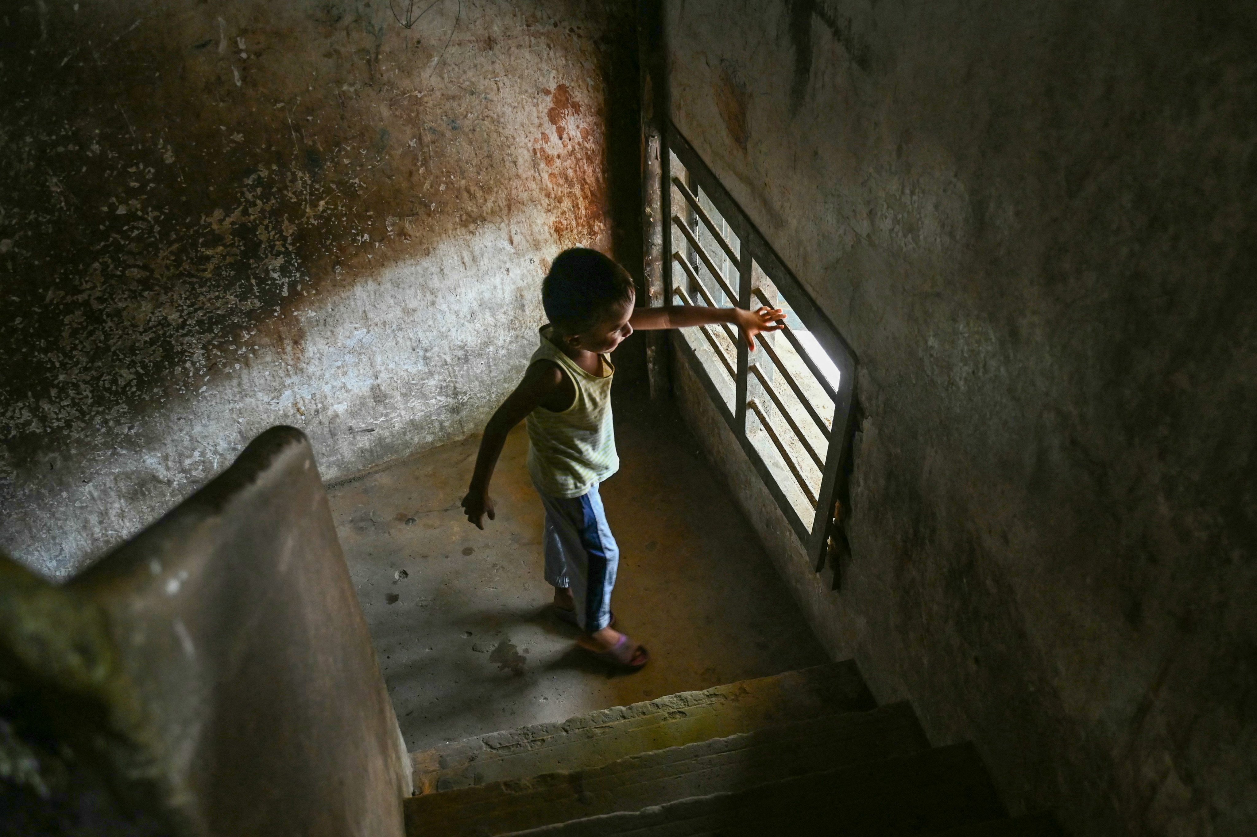 A Rohingya refugee child looks out through the bars of a window at a camp on the outskirts of Chennai, India. Photo: AFP