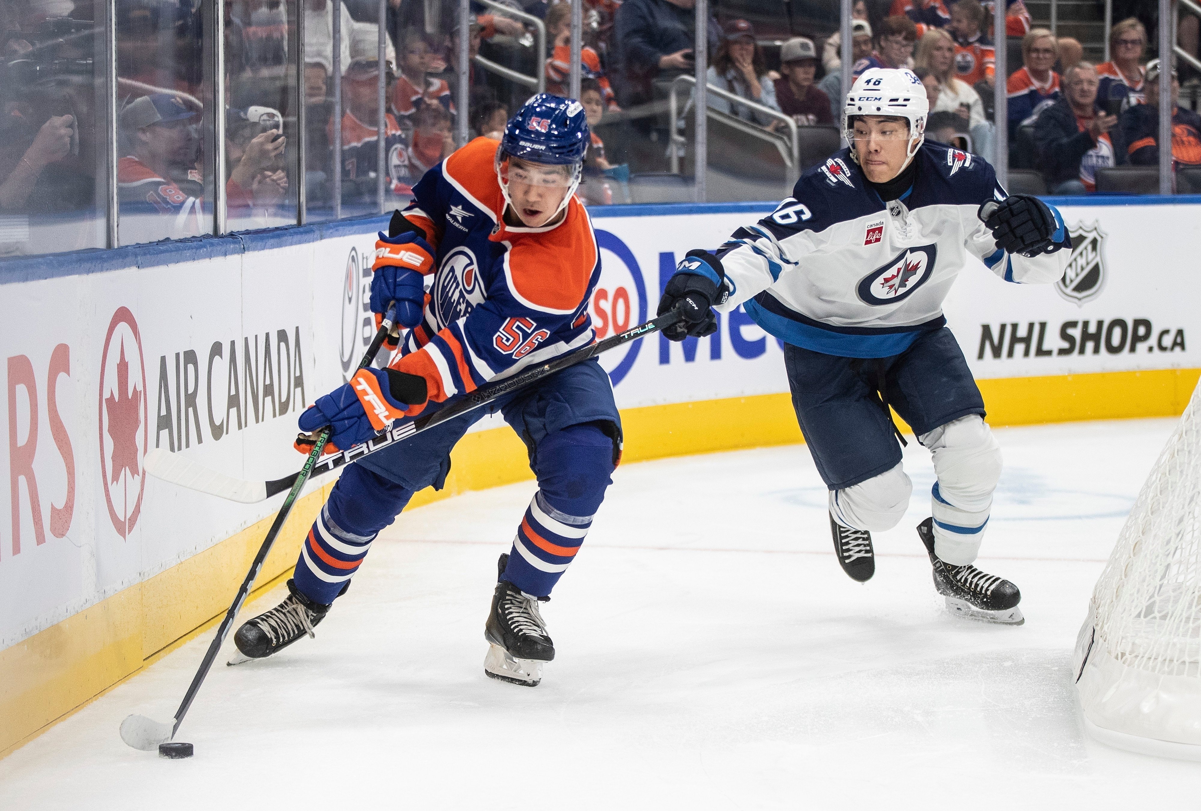 Winnipeg Jets’ Kevin He (right) and Edmonton Oilers’ William Nicholl battle for the puck during the second period of a NHL pre-season game in Edmonton. Photo: AP