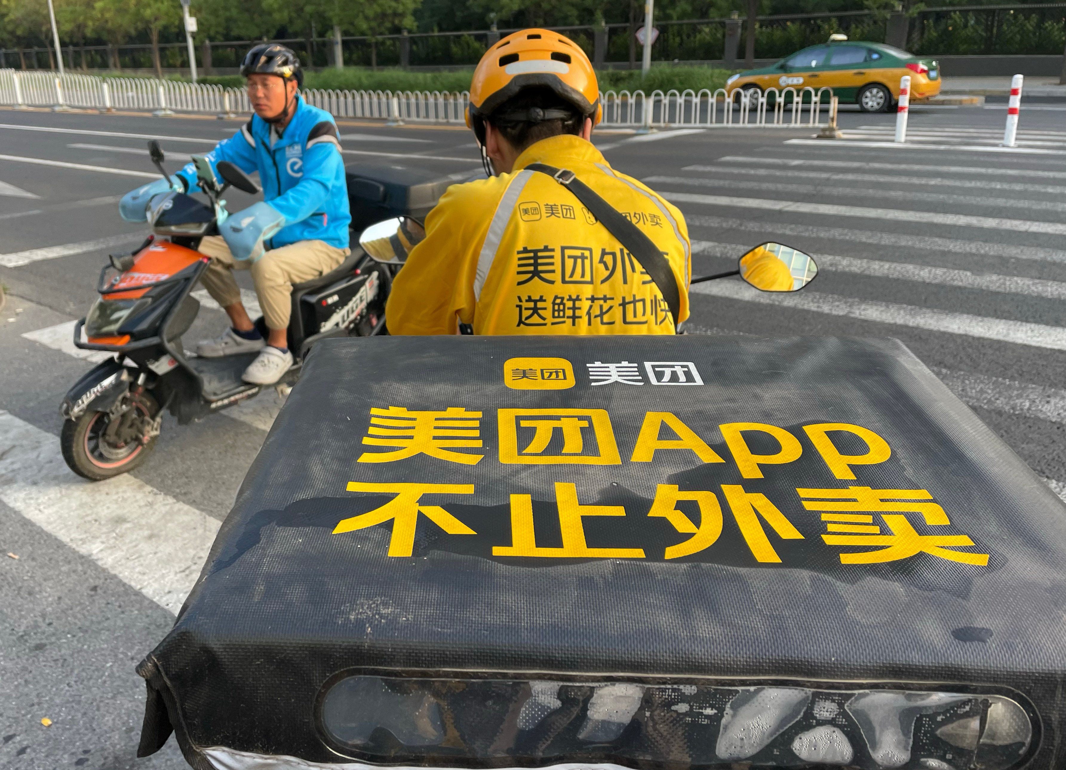 Food delivery couriers for Ele.me (left) and Meituan cross paths in Beijing on September 01, 2023. Photo: Simon Song