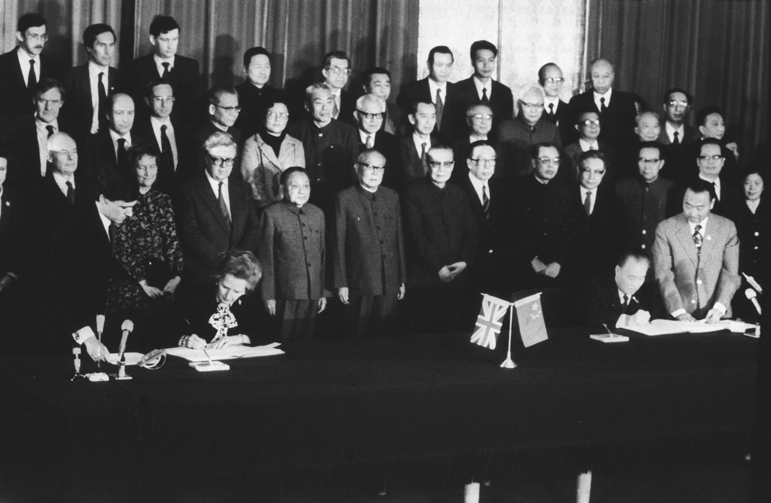 In Beijing, the British Prime Minister Margaret Thatcher, and the Chinese Prime Minister Zhao Ziyang, sign the Sino-British Joint Declaration on December 19, 1984, while officials from both sides look on. Photo: SCMP