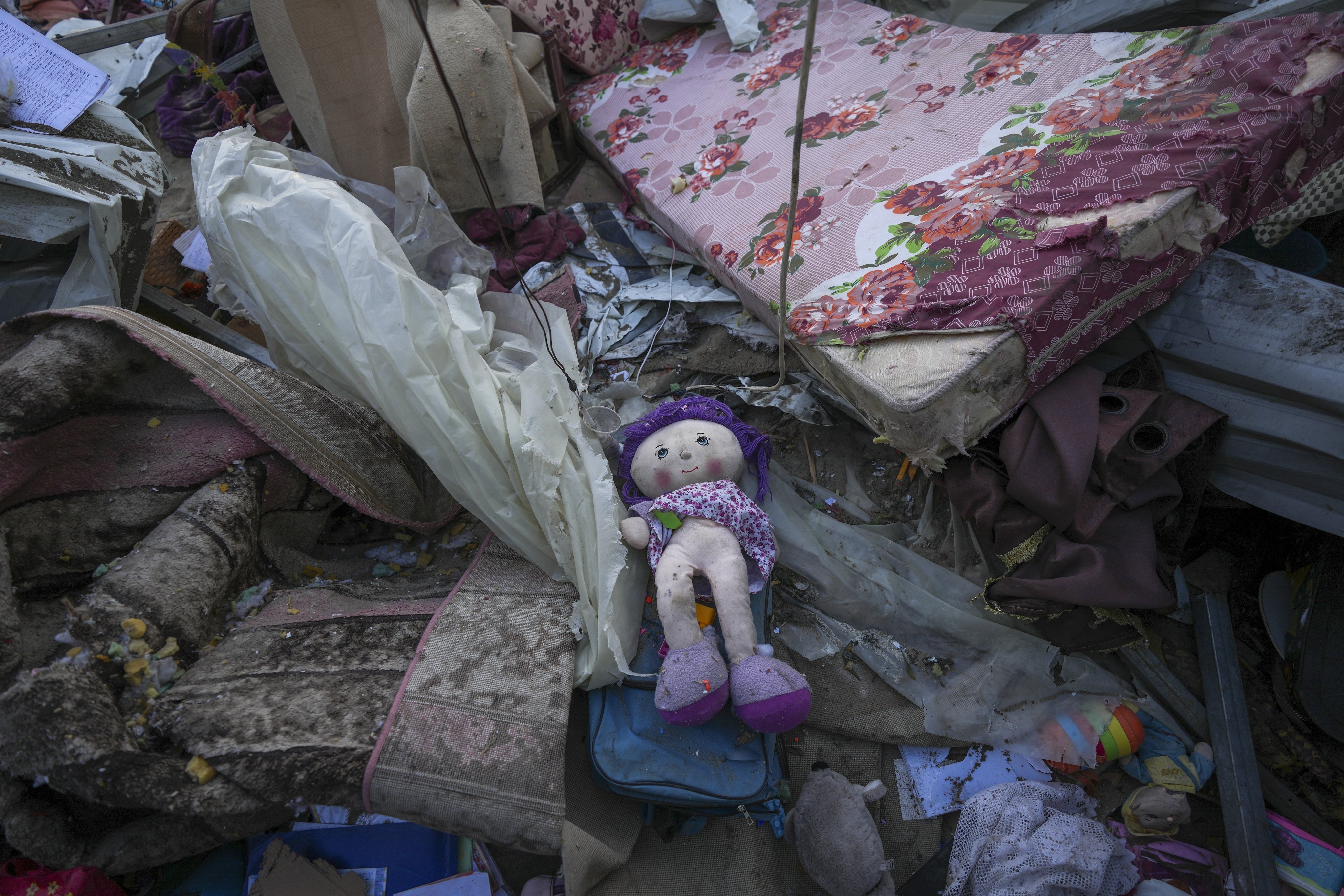 A doll lies among clothes and debris in the aftermath of an Israeli air strike at the Muwassi camp near Khan Younis in Gaza on December 5. Photo: AP