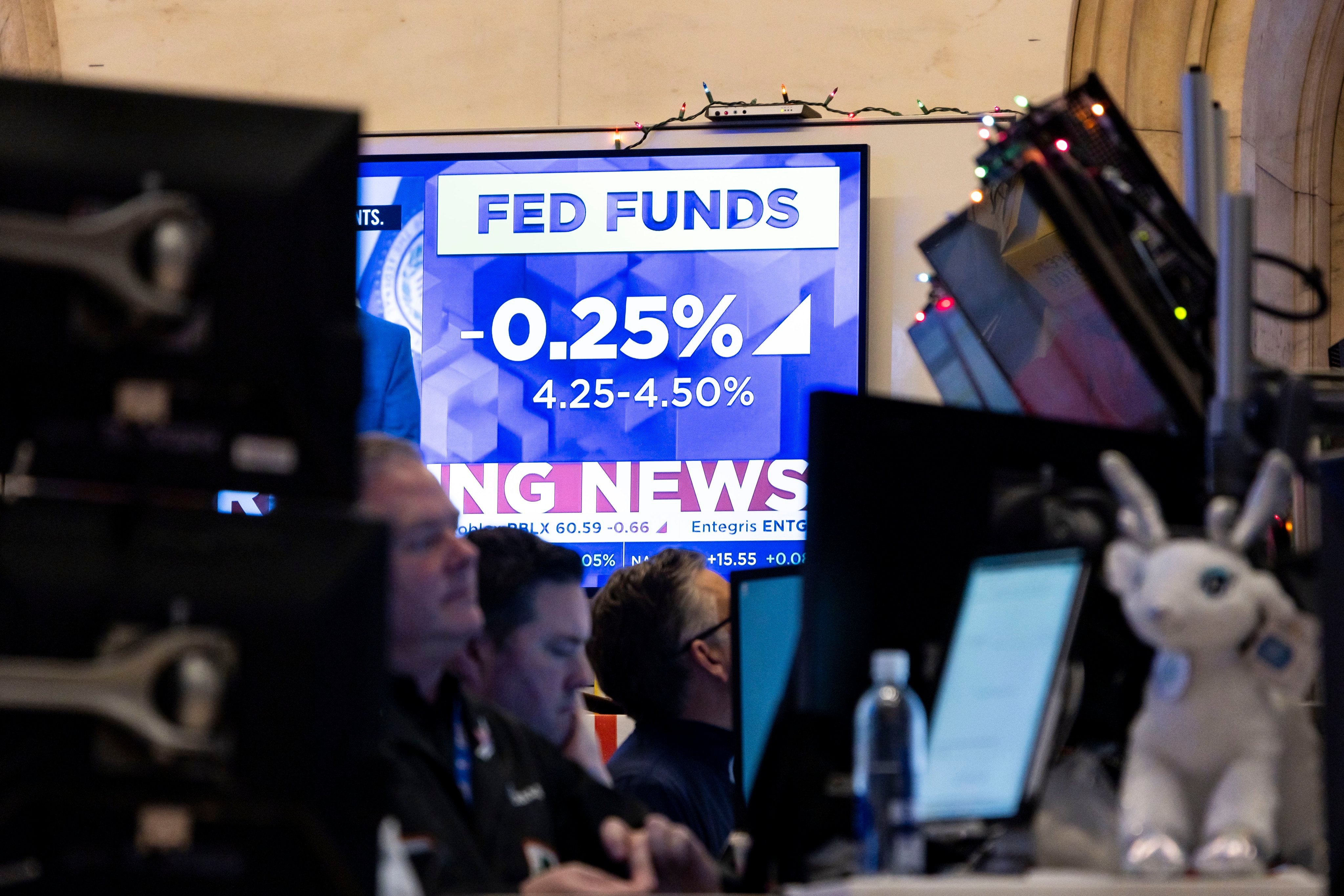 News of the US Federal Reserve’s move to cut its benchmark lending rate by 25 basis points flashes on a television screen as traders work at the New York Stock Exchange. Photo: EPA-EFE