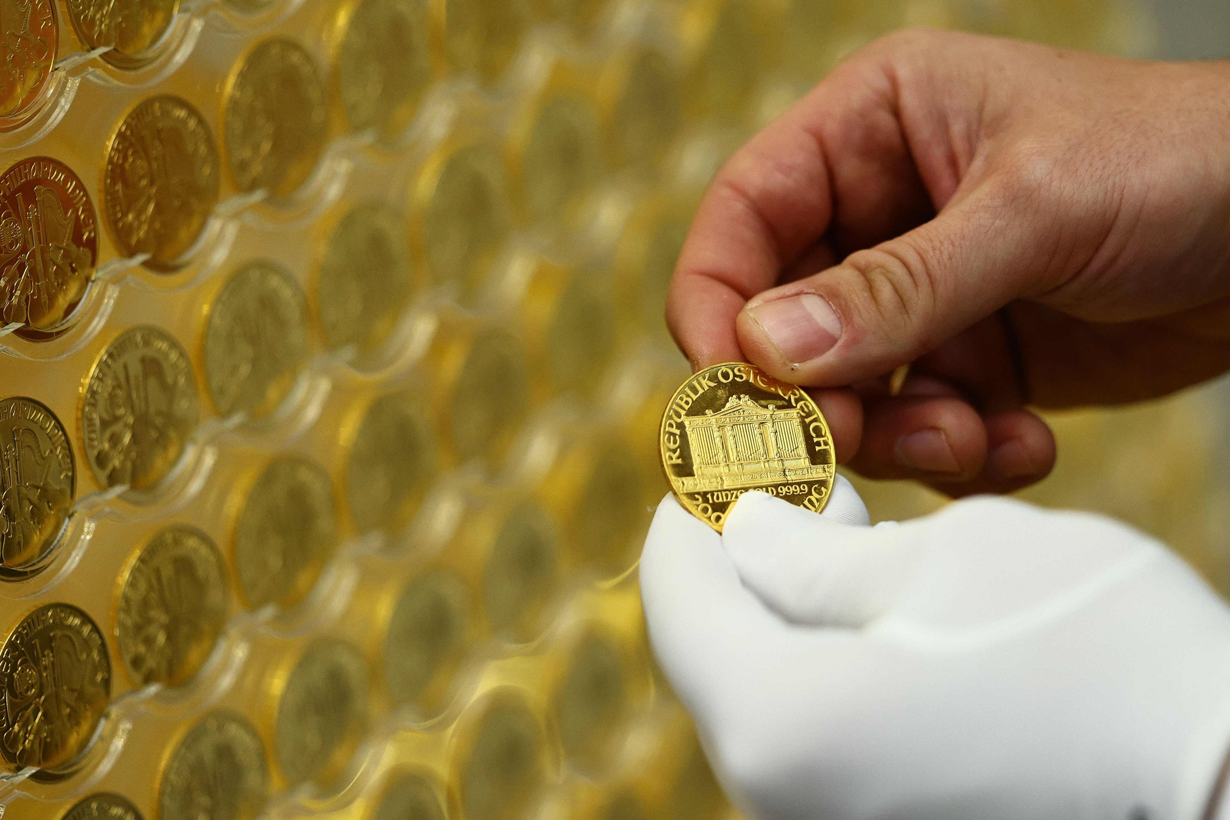 A worker takes a coin from a gold tree consisting of 2,024 Vienna Philharmonic coins displayed in Munich on December 3. Based on the current gold price, the tree, which is almost 3 metres tall, has a value of about 5.3 million euros (US$5.5 million). Photo: EPA-EFE