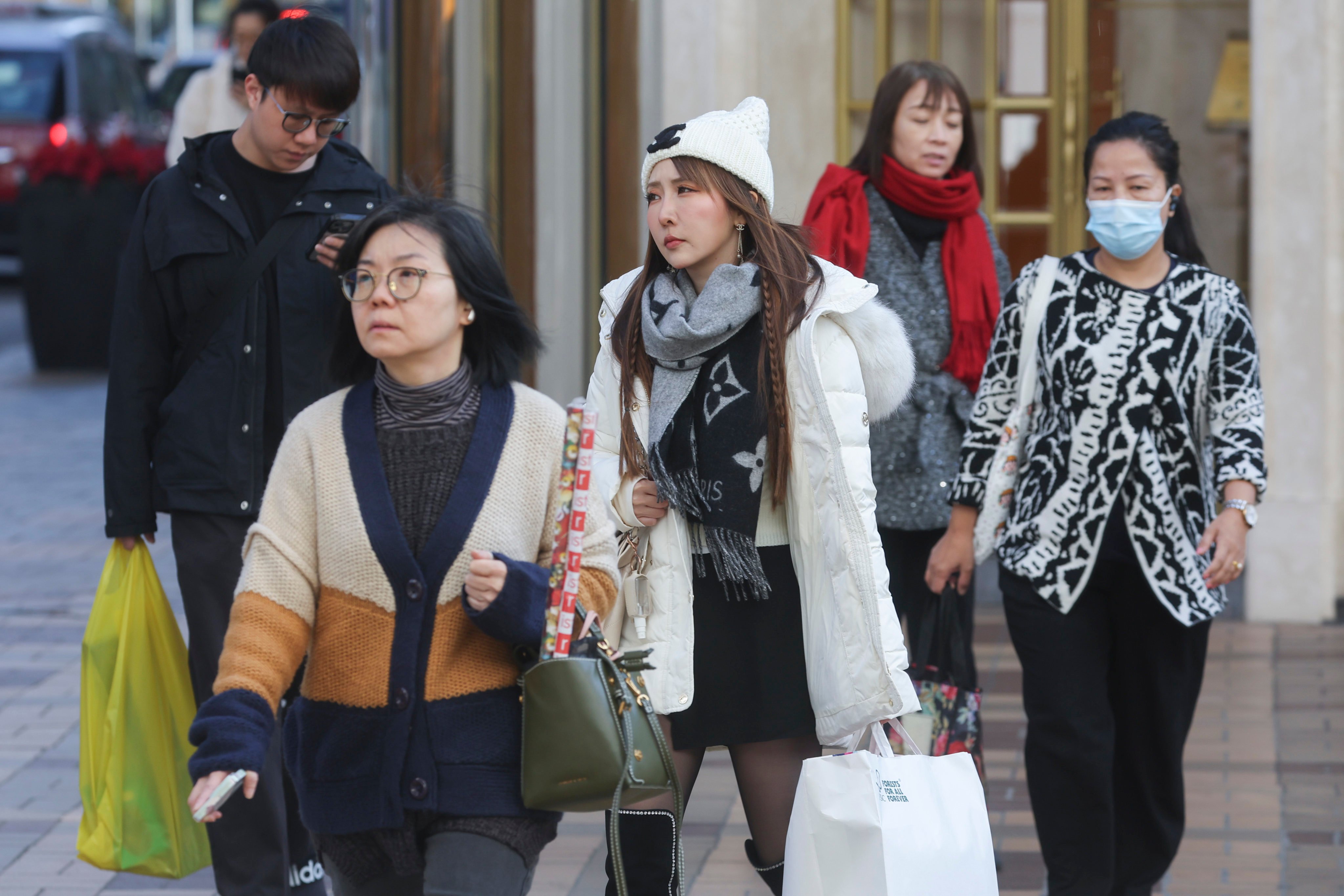 People in Tsim Sha Tsui don warmer clothing as the temperature drops. Photo: Edmond So