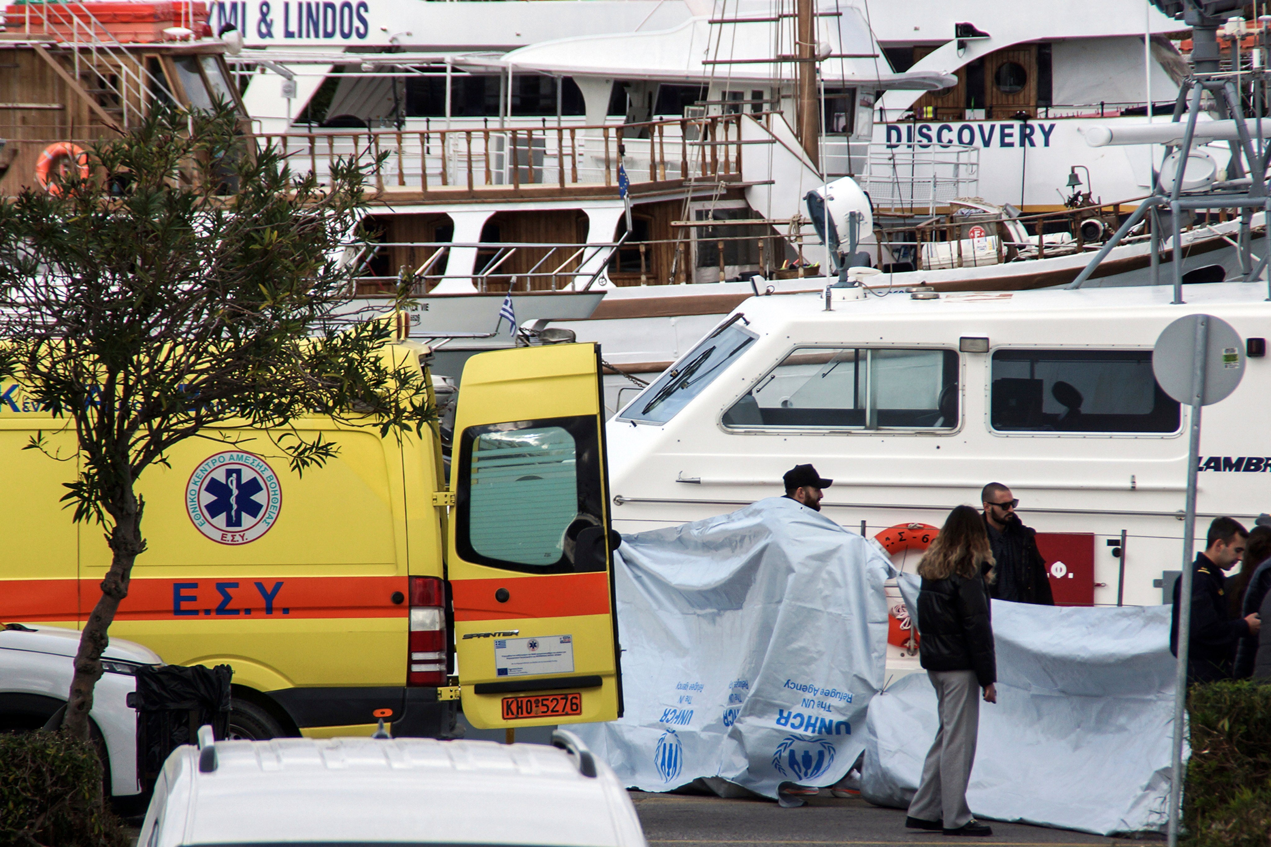 Coastguard officers cover  bodies after a speedboat carrying migrants capsized near the island of Rhodes, Greece, on Friday. Photo: AP