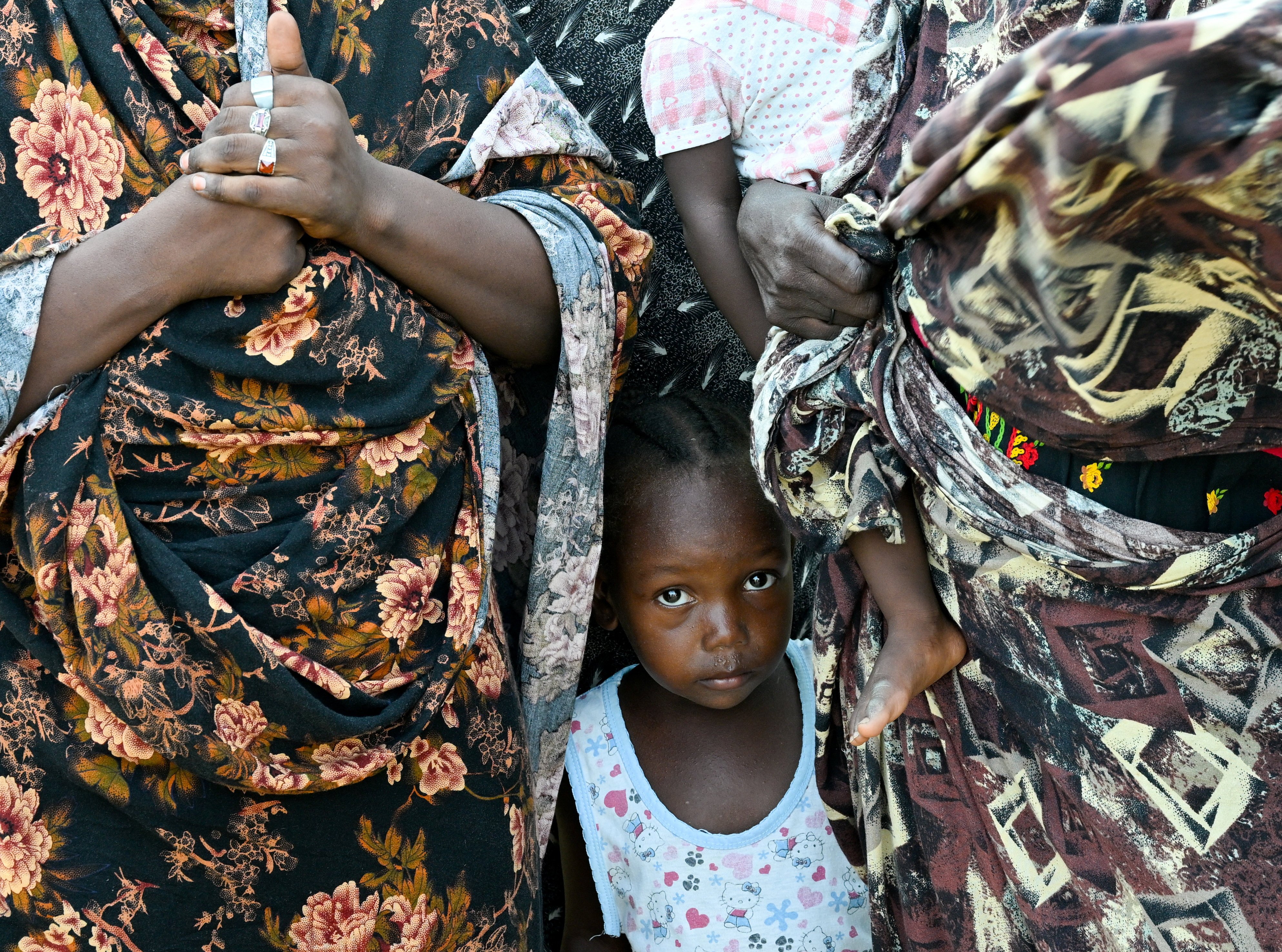 A child stands between two women at a school turned into a shelter, in Port Sudan, Sudan, in August. Millions of people in the region do not have enough food. Photo: Reuters