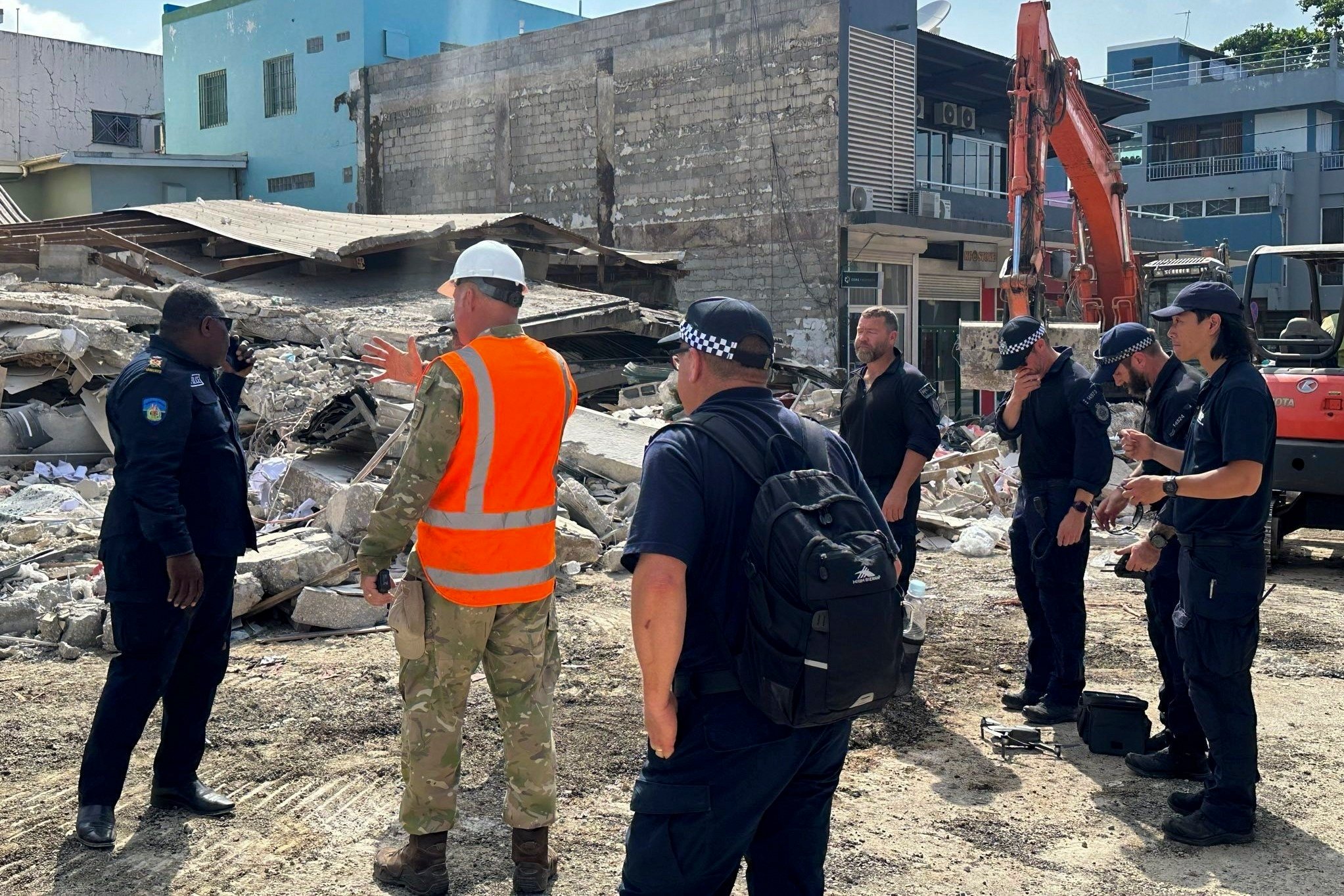 Members of Australia’s federal police and other rescue workers stand by a collapsed building in Port Vila, Vanuatu. Photo: Australian Federal Police via AP