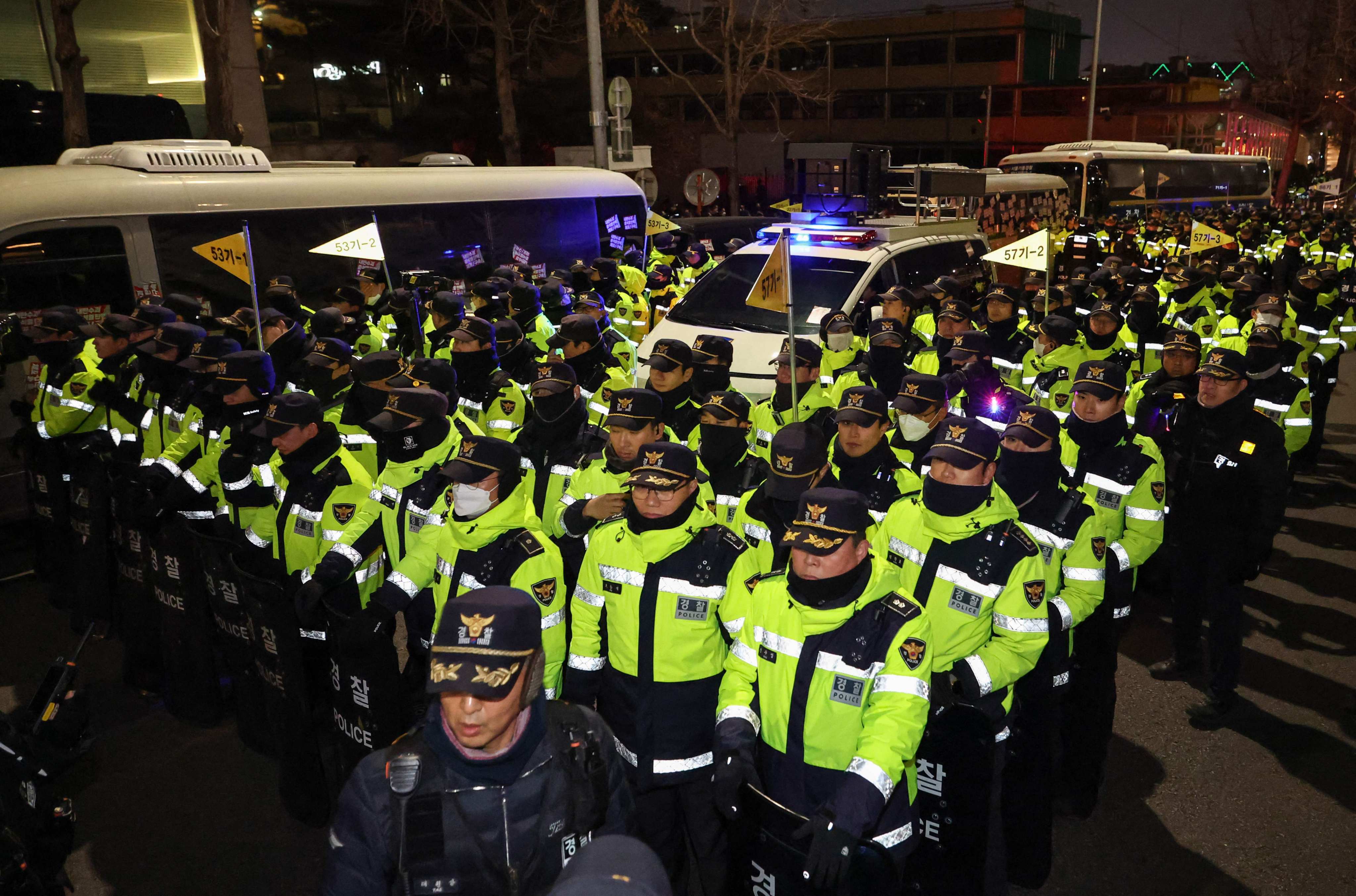 Police stand guard at the entrance of the presidential office in Seoul as people take part in a protest calling for the ouster of South Korean leader Yoon Suk-yeol on December 12. Photo: Yonhap/AFP
