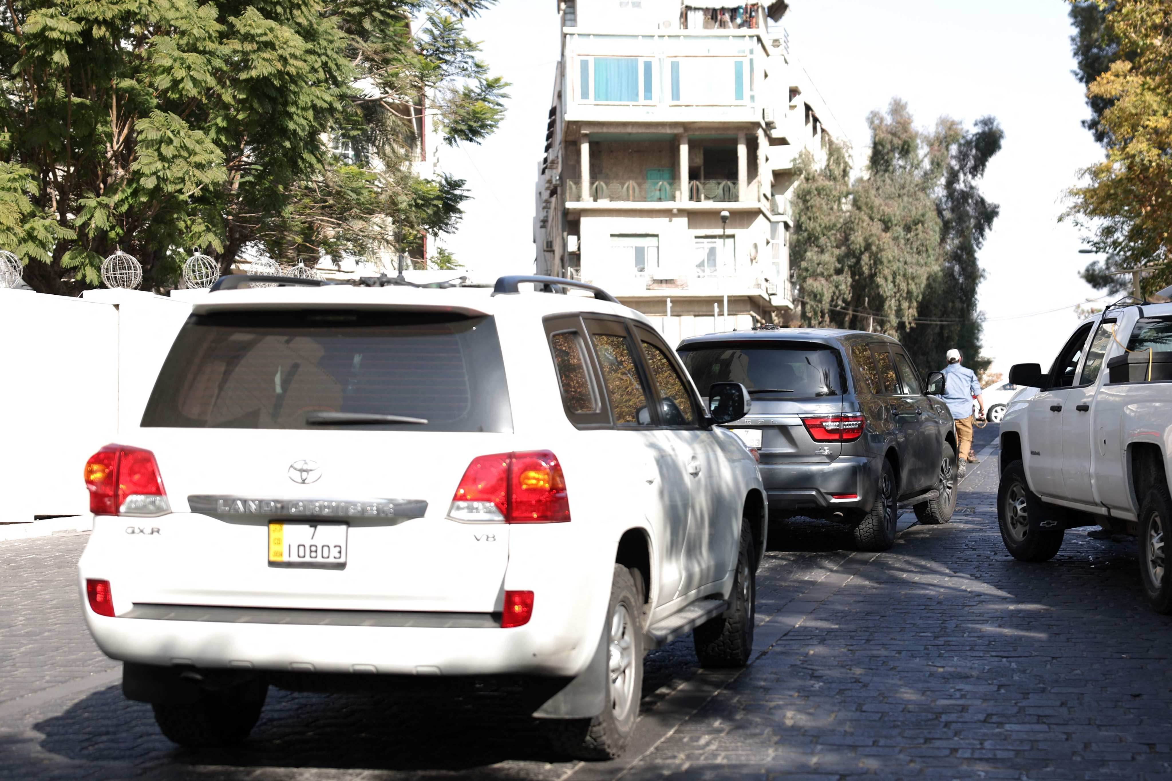 Cars belonging to a US delegation drive in a street in Damascus, Syria, on Friday. Photo: AFP