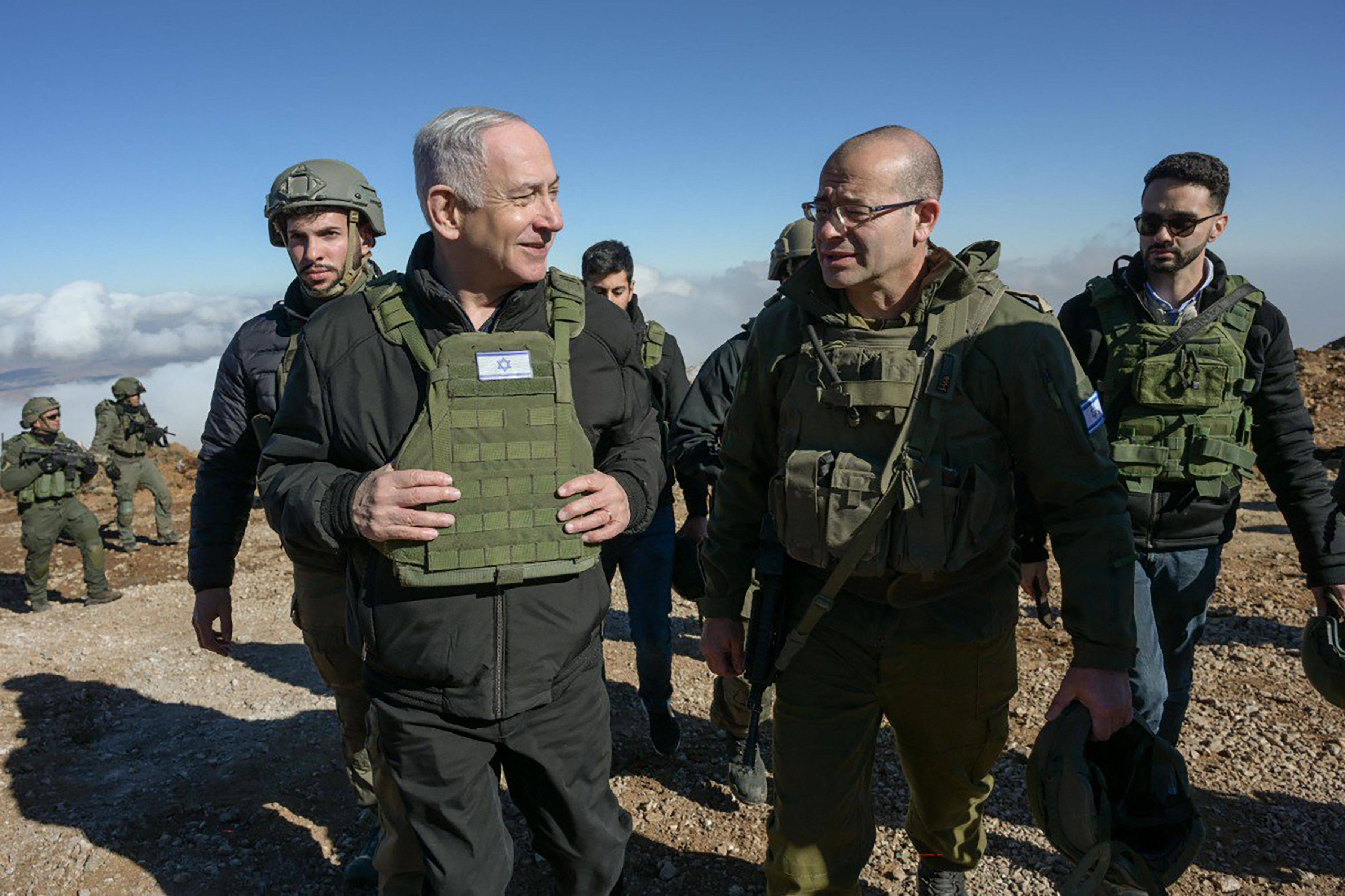 Israeli Prime Minister Benjamin Netanyahu (left) walks with soldiers at the seized Mount Hermon in the Golan Heights, near the border with Syria, on Tuesday. Photo: Government Press Office / AFP