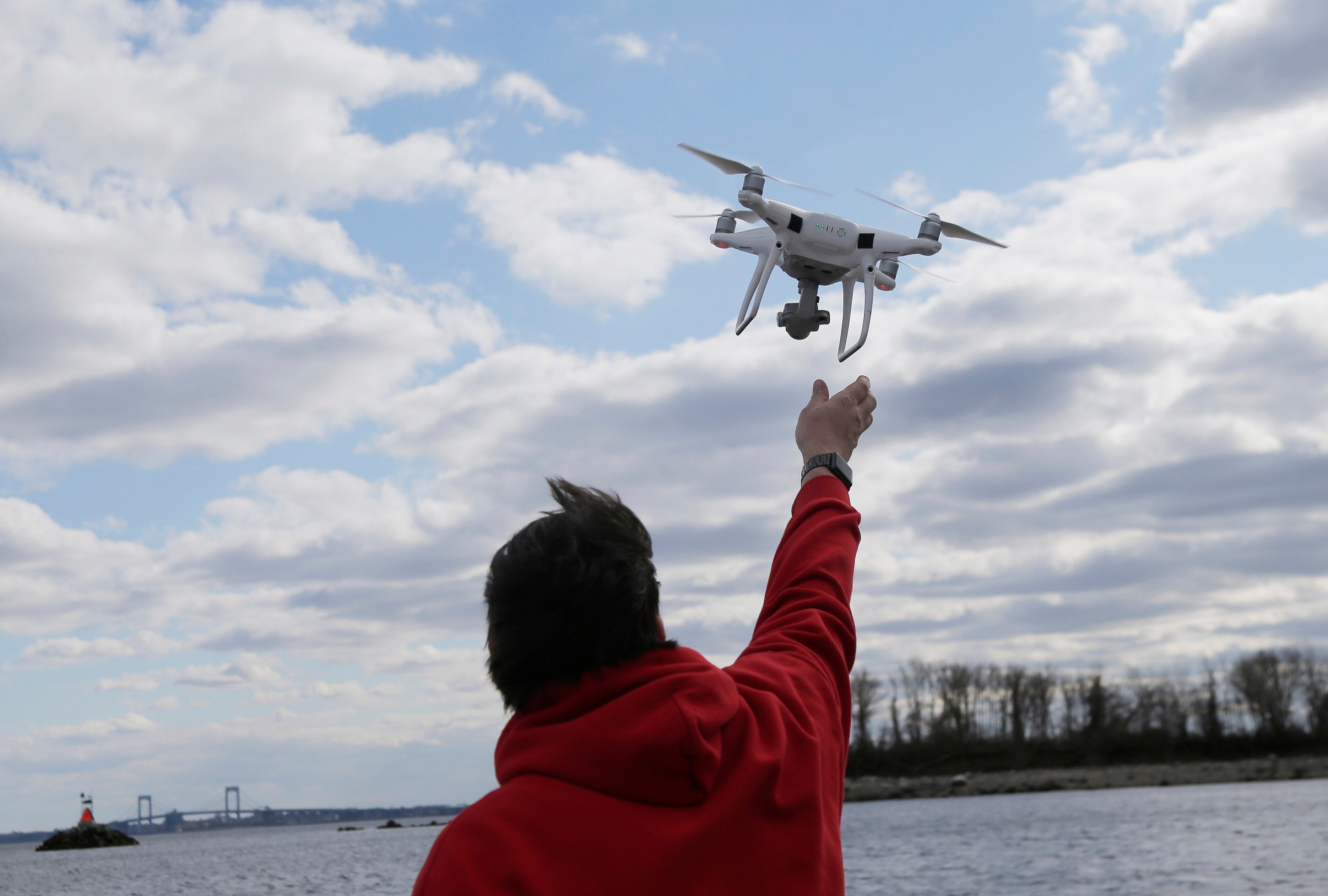 A drone operator retrieves a drone after photographing over Hart Island in New York in April 2018. Photo: AP