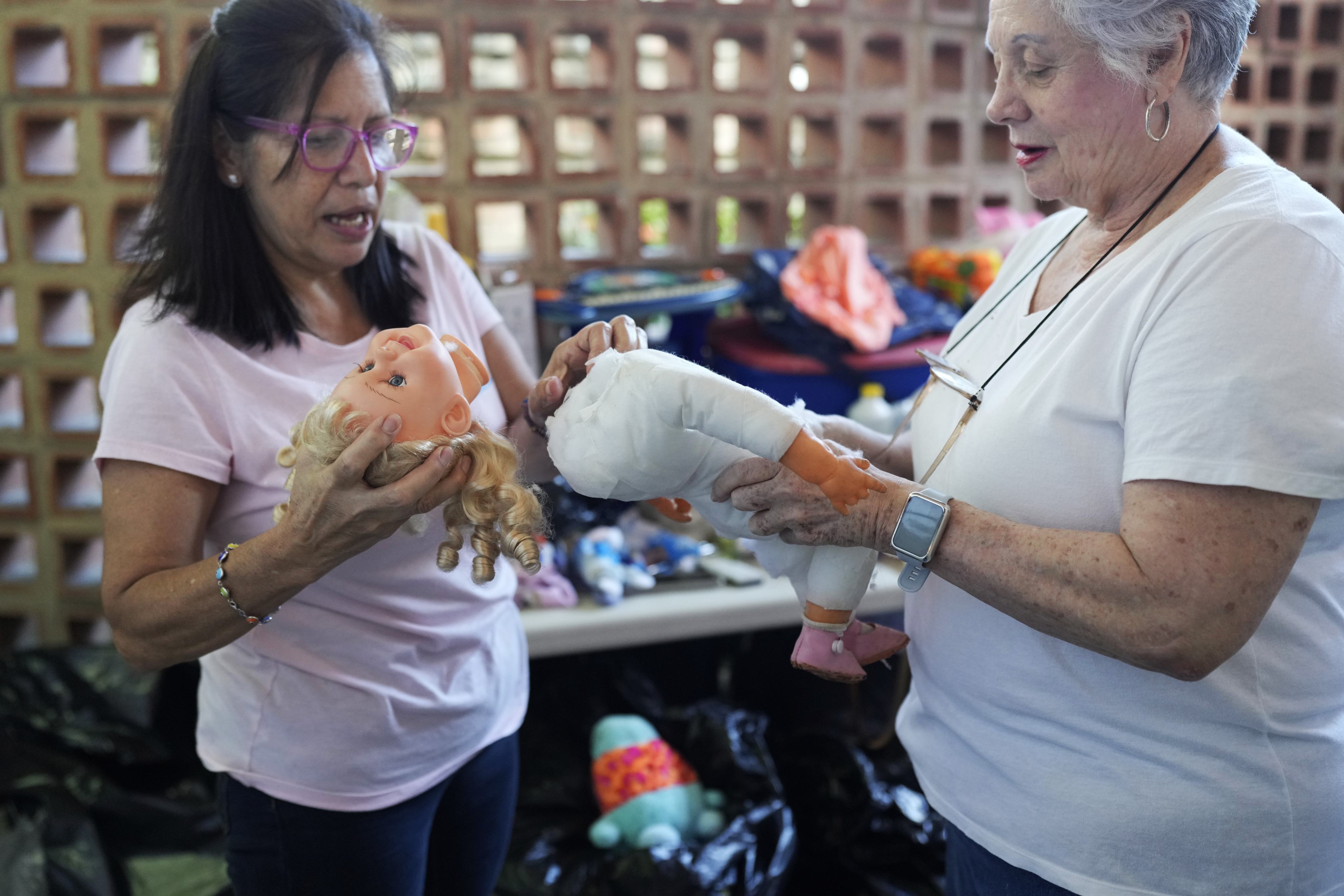 Volunteers discuss the best way to restore a doll at the Hospital for Soft Toys in Venezuela, which fixes old toys to distribute to hospitals, schools in poor areas, and lonely old people in the economically strained country. Photo: AP