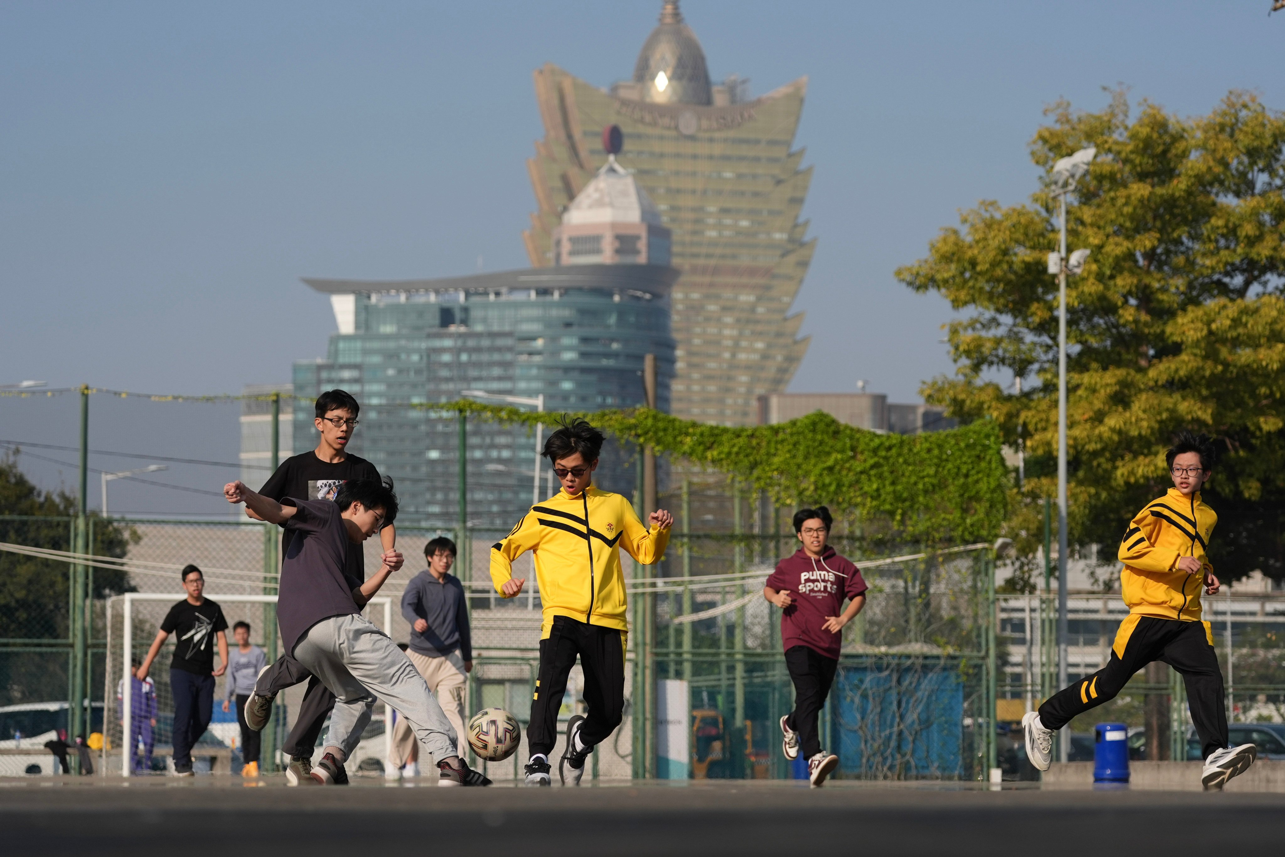 Youths play football near the Macau Tower, with the Grand Lisboa casino in the background. Photo: Eugene Lee