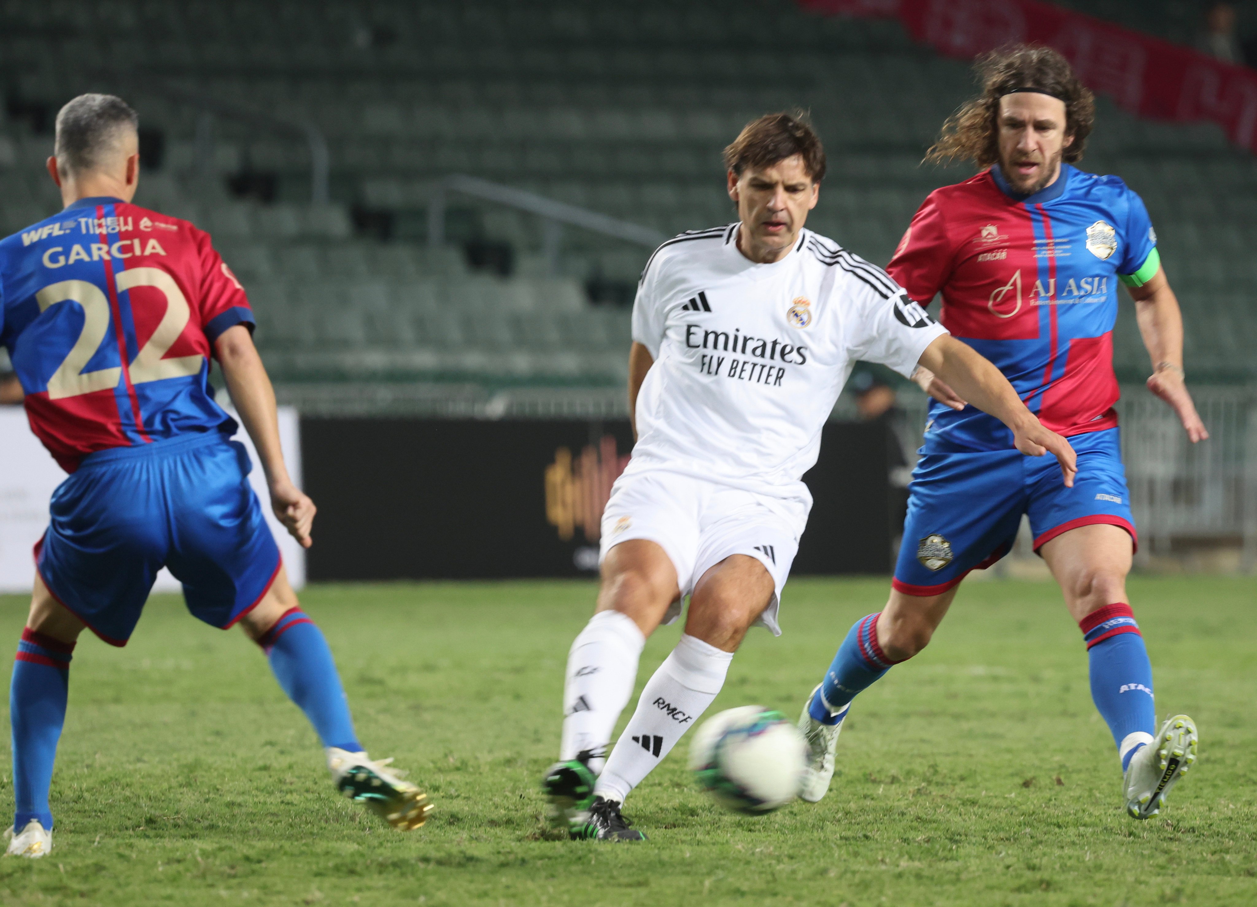 Carles Puyol shadows Fernando Morientes in front of rows of empty seats at Hong Kong Stadium. Photo: Dickson Lee