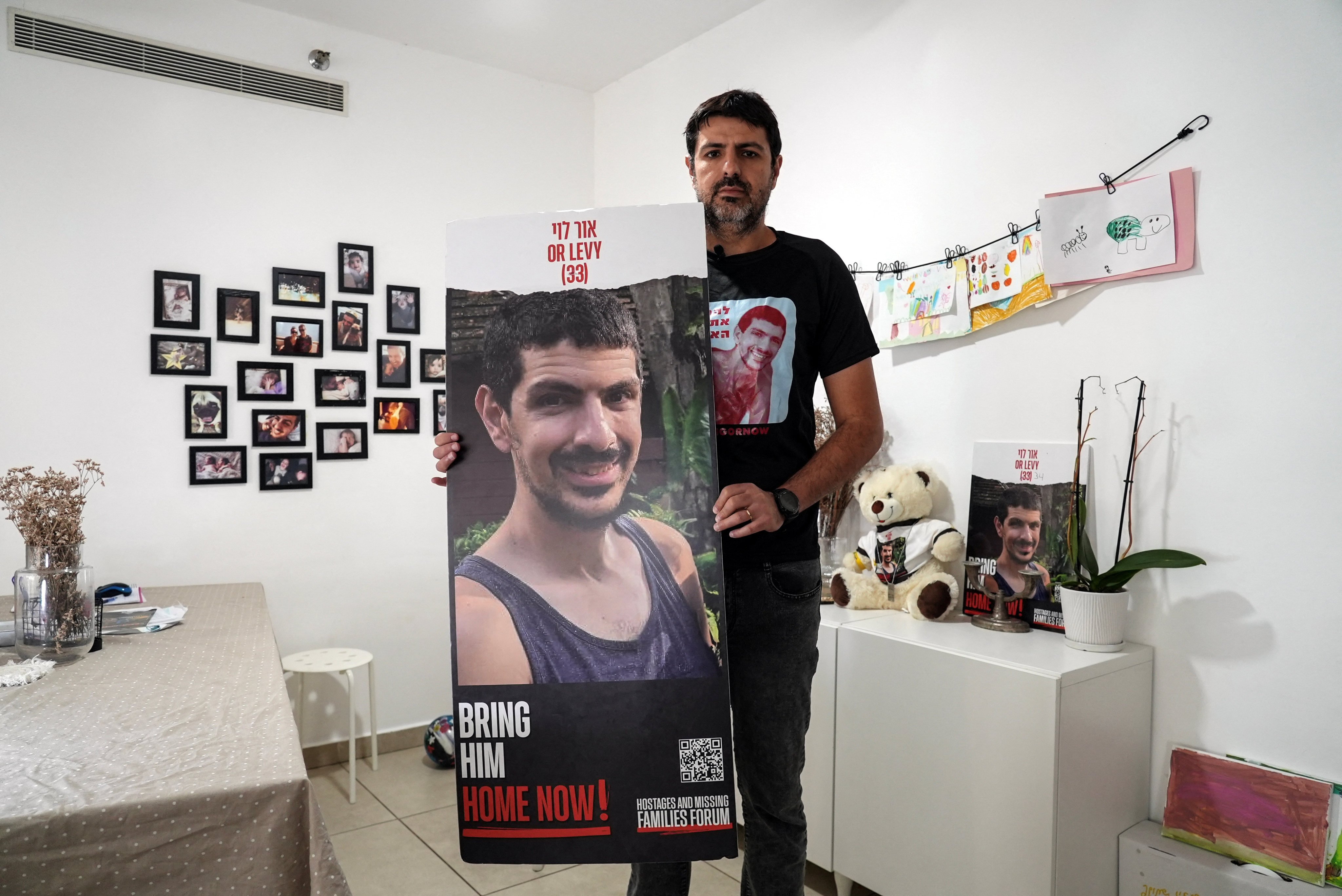 Michael Levy, the brother of Or Levy, 34, who has been held hostage in Gaza since he was abducted during last year’s attack by Hamas, holds a poster of Or during an interview on Tuesday. Photo: Reuters