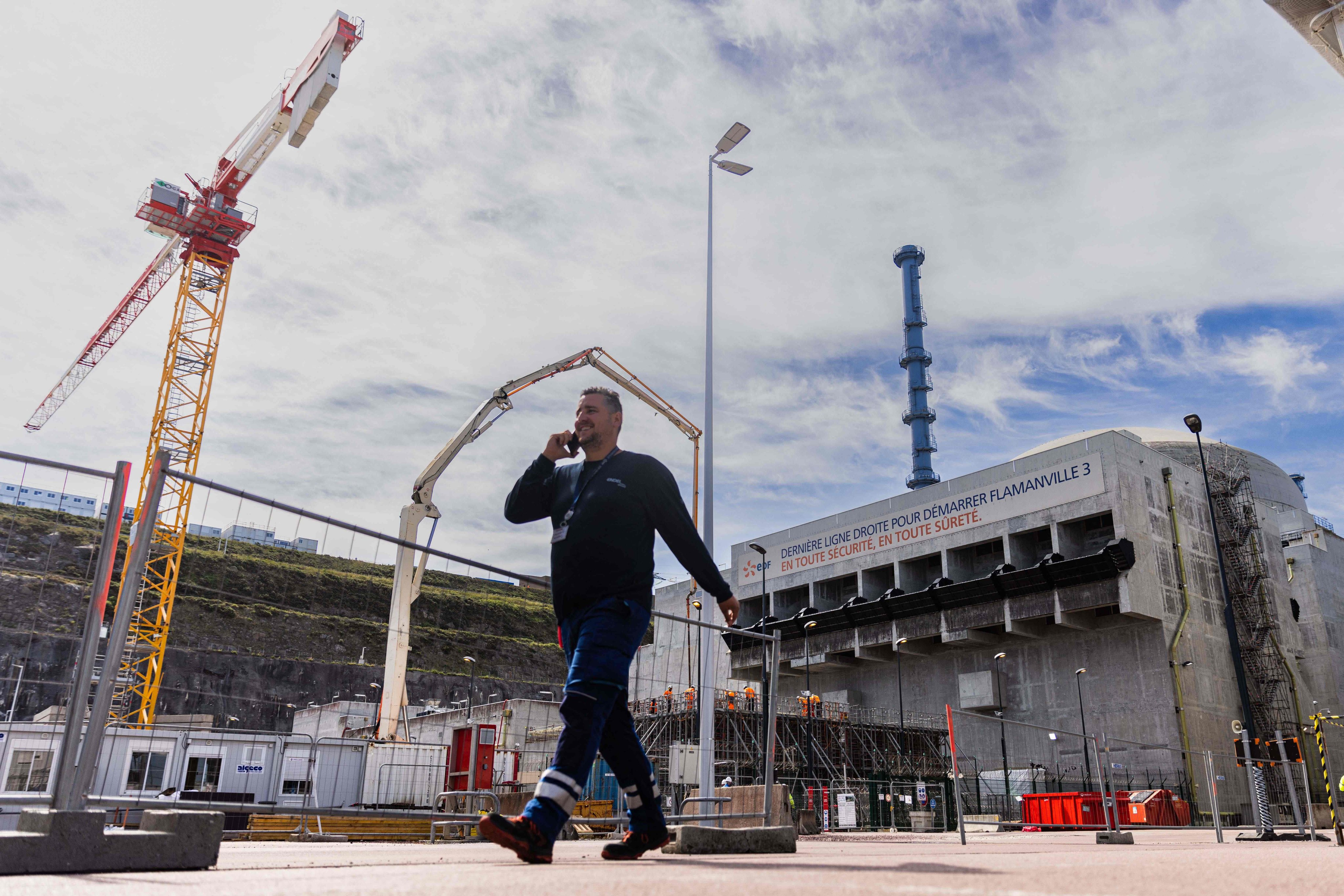 A worker walks past a reactor building at the third-generation European Pressurised Reactor project nuclear reactor of Flamanville, Normandy. Photo: AFP