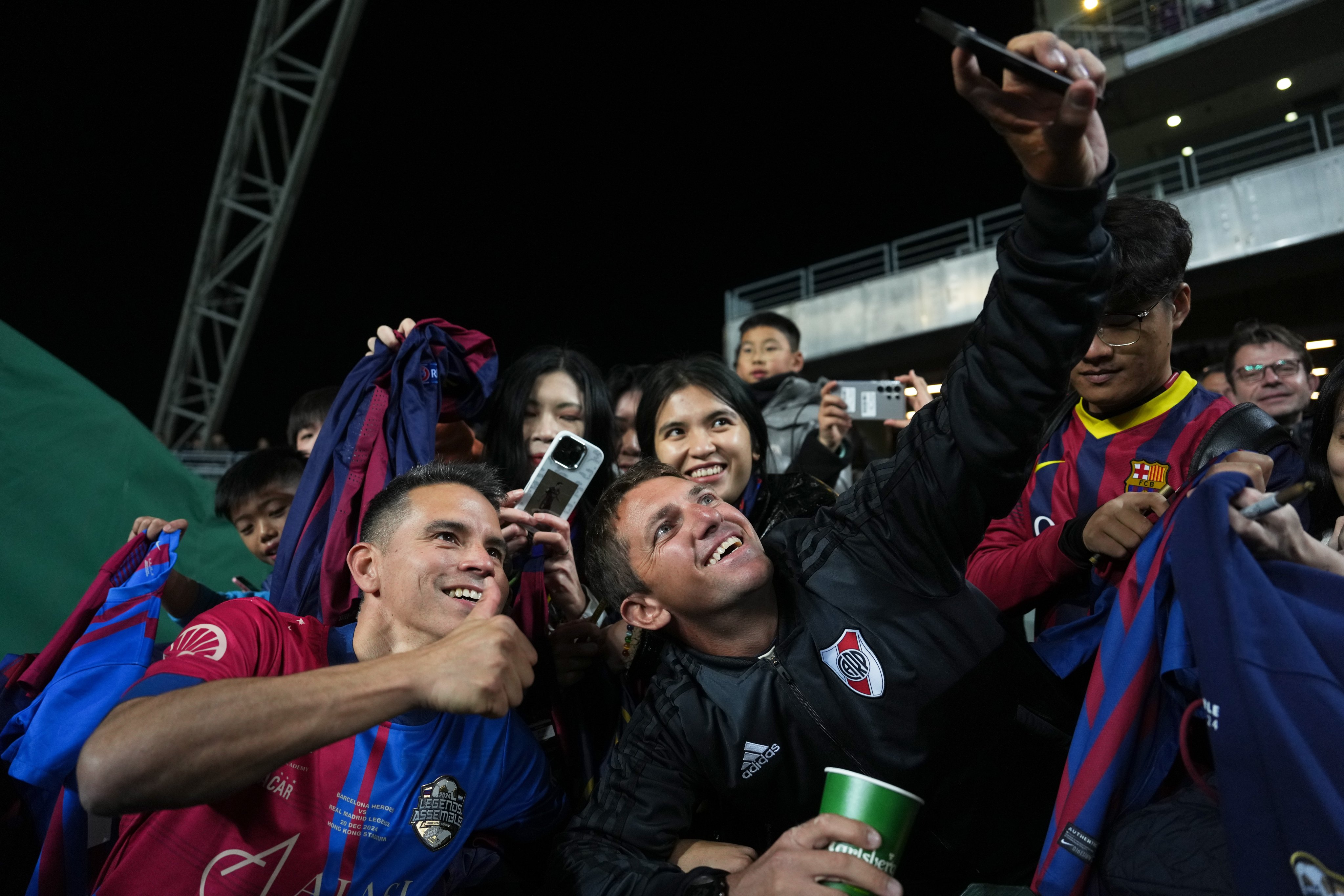 A fan takes a selfie photo with former Barcelona player Javier Saviola (left) before the game between FC Barcelona Heroes and Real Madrid Legends at  Hong Kong Stadium. Photo: EPA-EFE