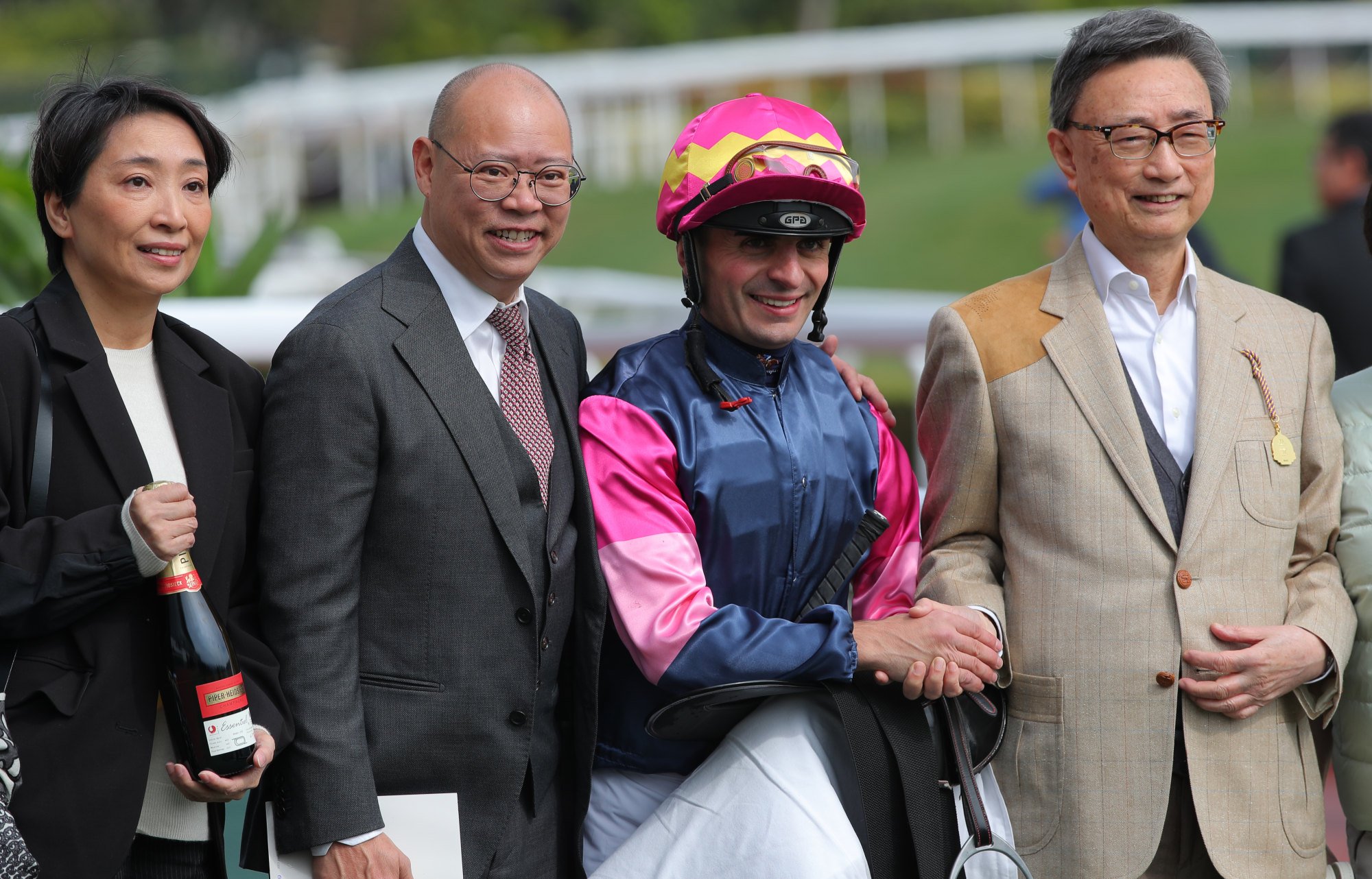 Jockey Andrea Atzeni celebrates a win with connections at Sha Tin.