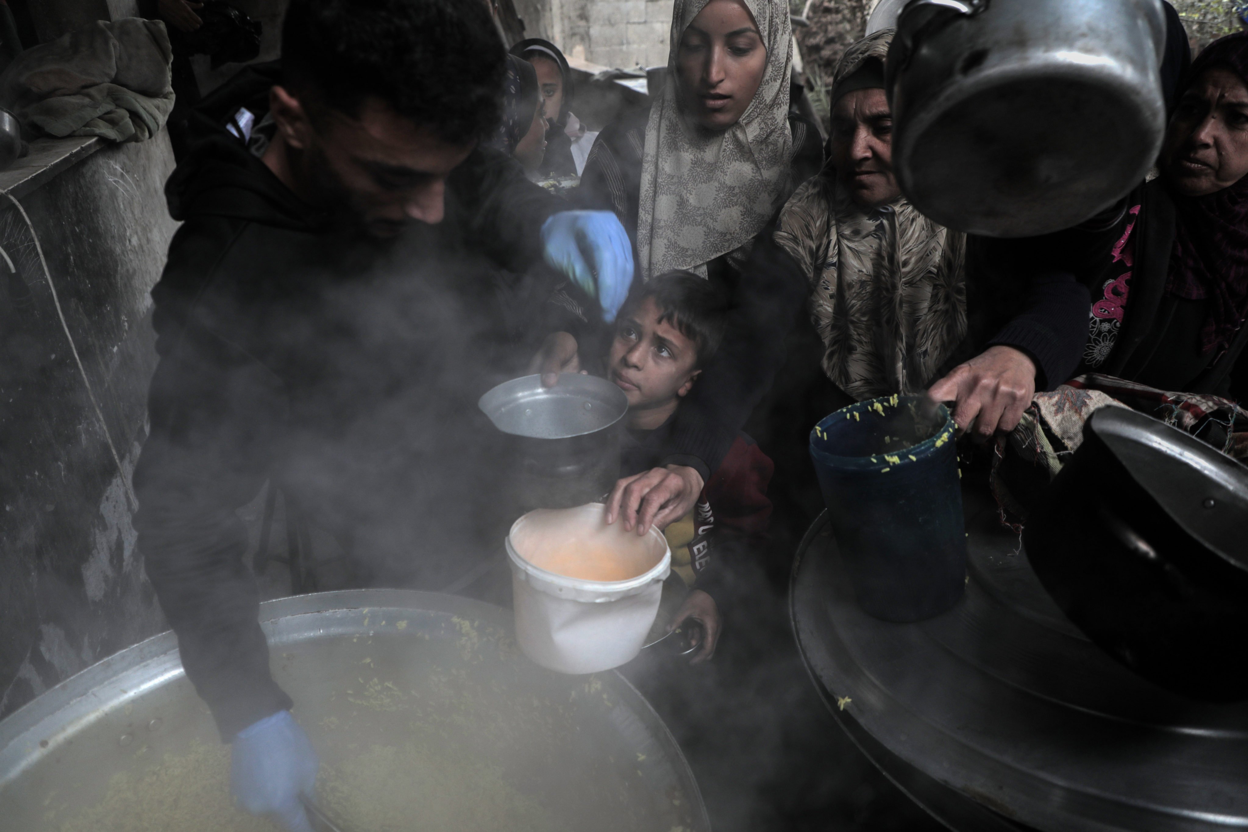 People receive food relief at a food distribution centre in the city of Deir al-Balah, central Gaza Strip. Photo: Xinhua