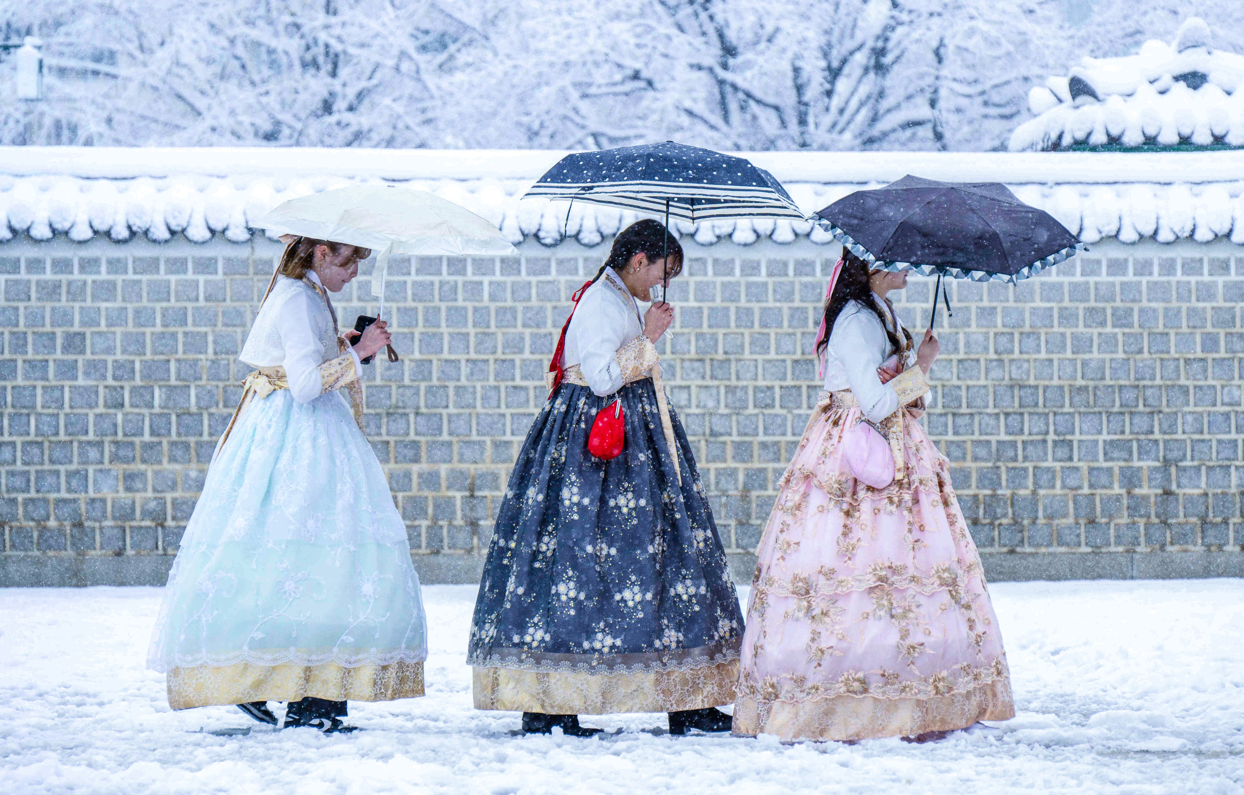 Visitors in traditional dresses on the grounds of Gyeongbokgung Palace amid heavy snowfall in Seoul in late November. Photo: AFP