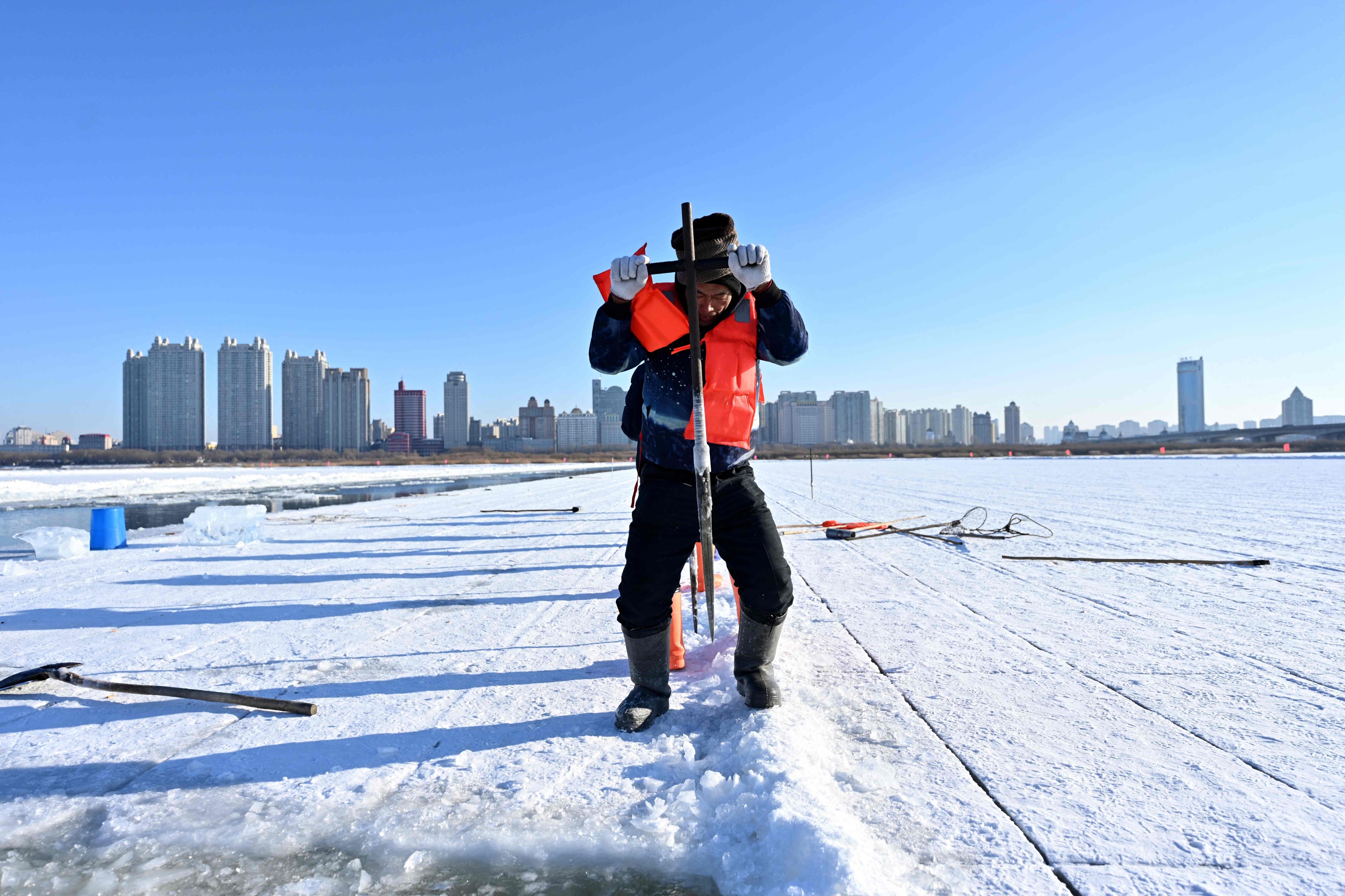 A worker harvests ice from the frozen Songhua River in preparation for the annual Harbin Ice and Snow World festival, in Harbin, Heilongjiang province. Photo: AFP