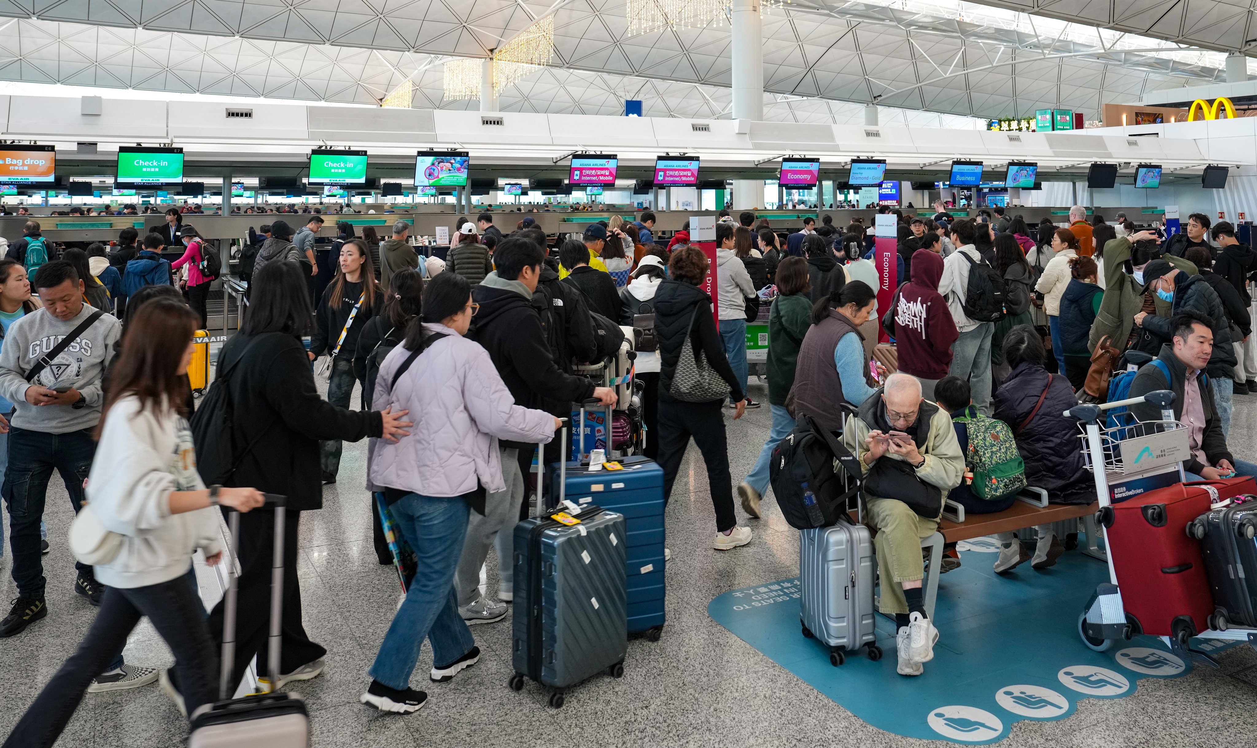 Travellers queue to check in at the departure hall of Hong Kong International Airport on Sunday morning. Photo: Elson Li