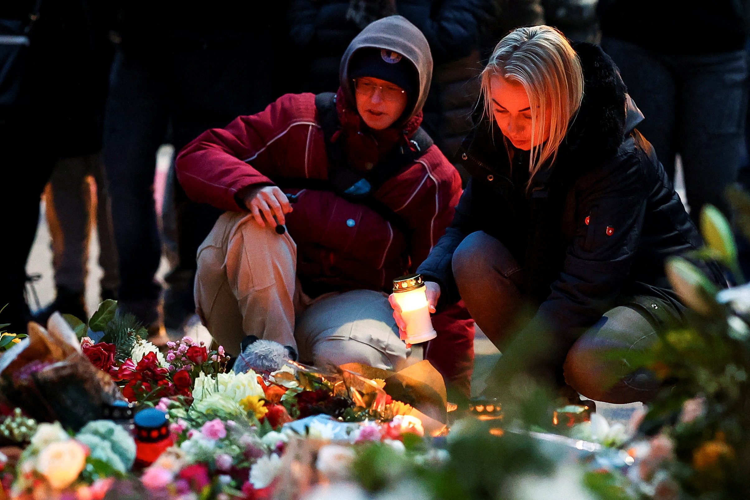 A woman holds a candle as people leave floral tributes to the victims on Saturday near the site where a car rammed into a crowd at a Magdeburg Christmas market. Photo: Reuters