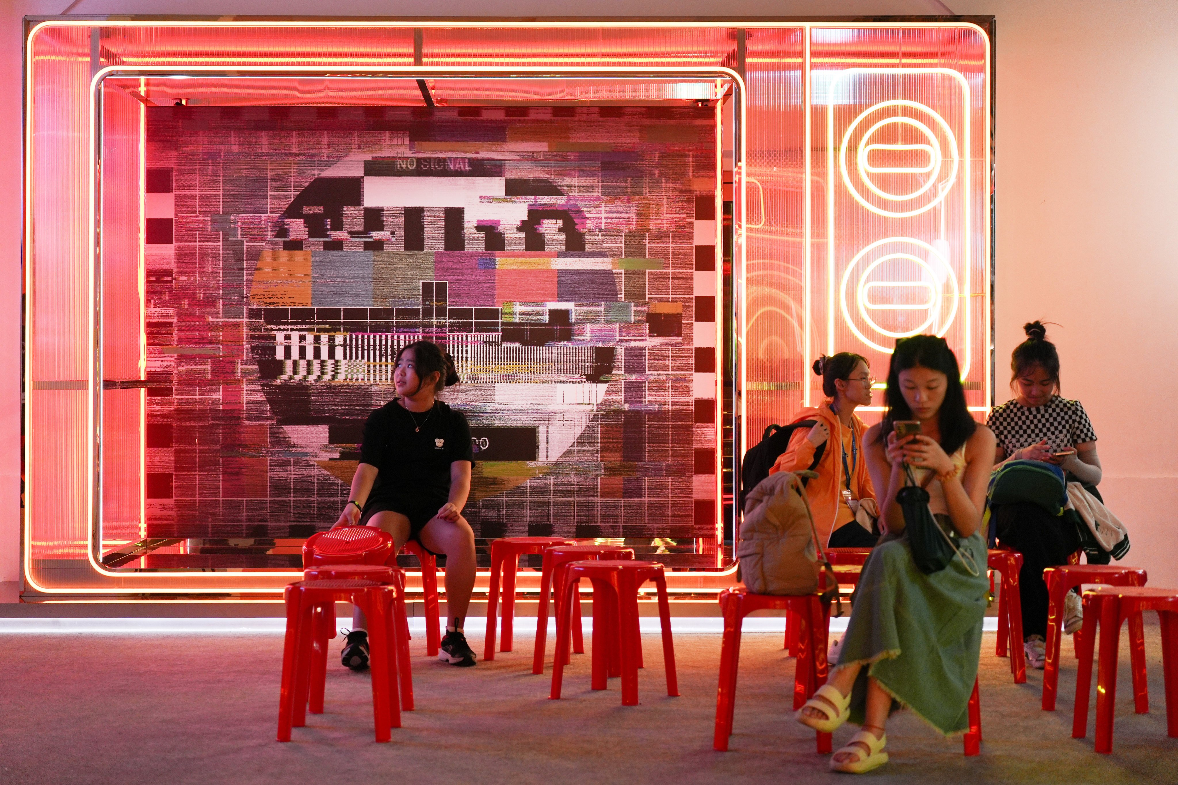 Patrons sit in front of neon light decorations at the “Soundtrack of Our Lives: Joseph Koo x James Wong x the Rise of Cantopop” exhibition at Tai Kwun in Central, on July 15. Photo: Eugene Lee