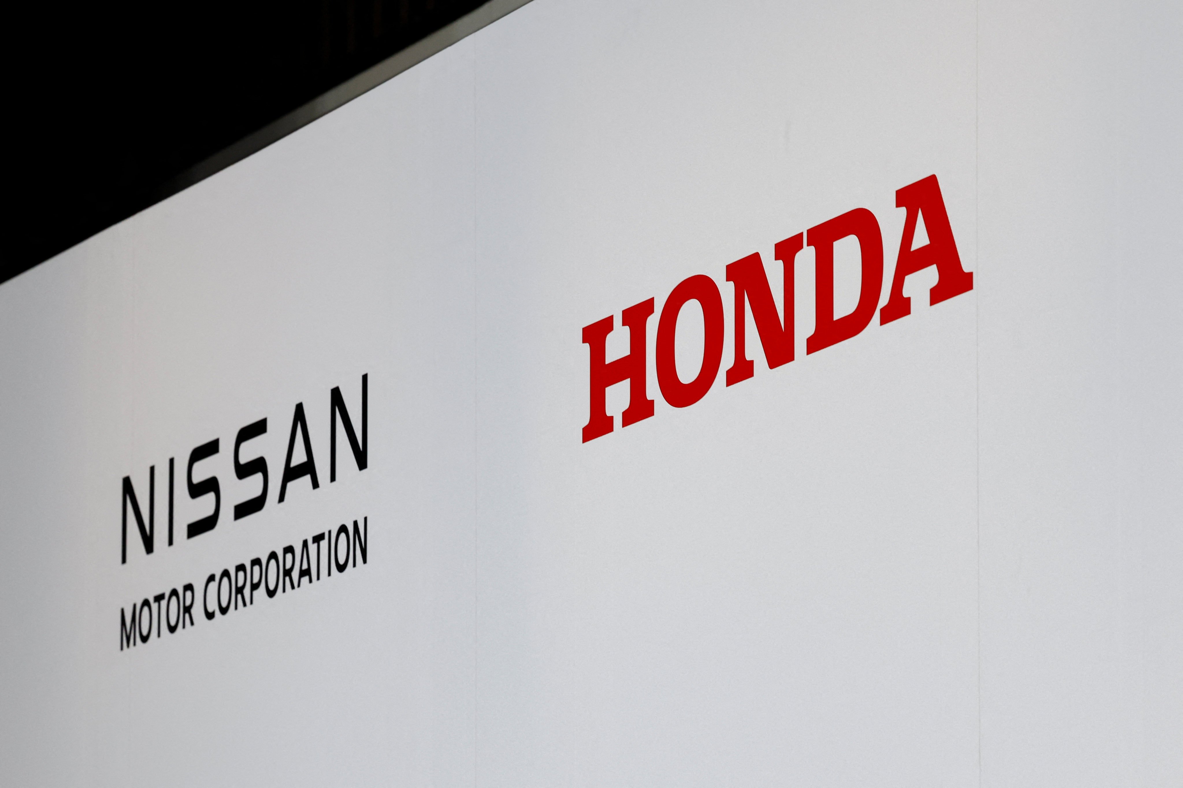 Logos of Nissan Motor Corporation and Honda are seen at a joint press conference on their merger talks, in Tokyo, Japan on December 23. Photo: Reuters