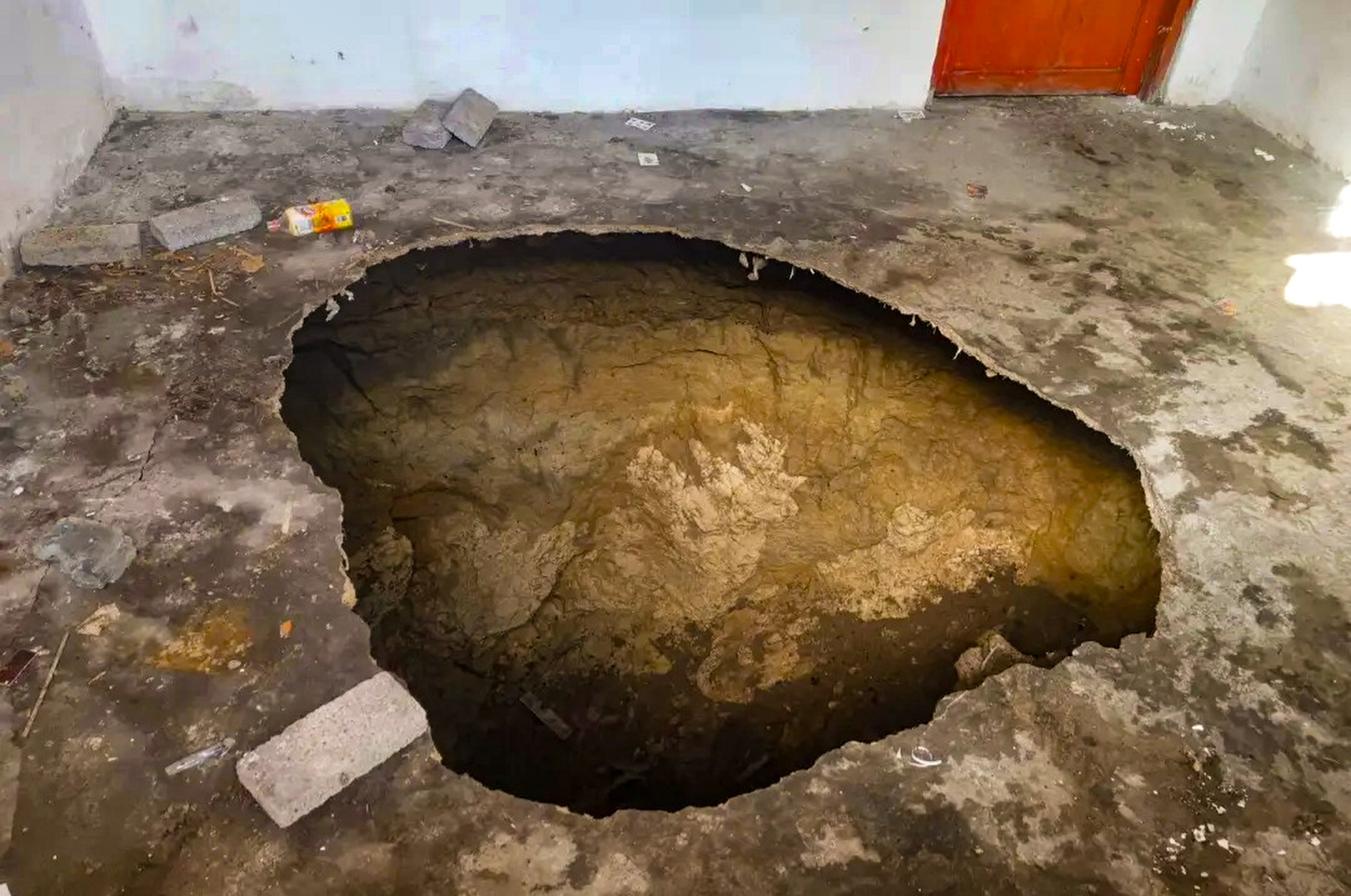 The gaping sinkhole that appeared in the middle of Hu Yuzhen’s kitchen floor in a village in Guizou province, southwest China on December 9. Photo: Weibo / 红星新闻