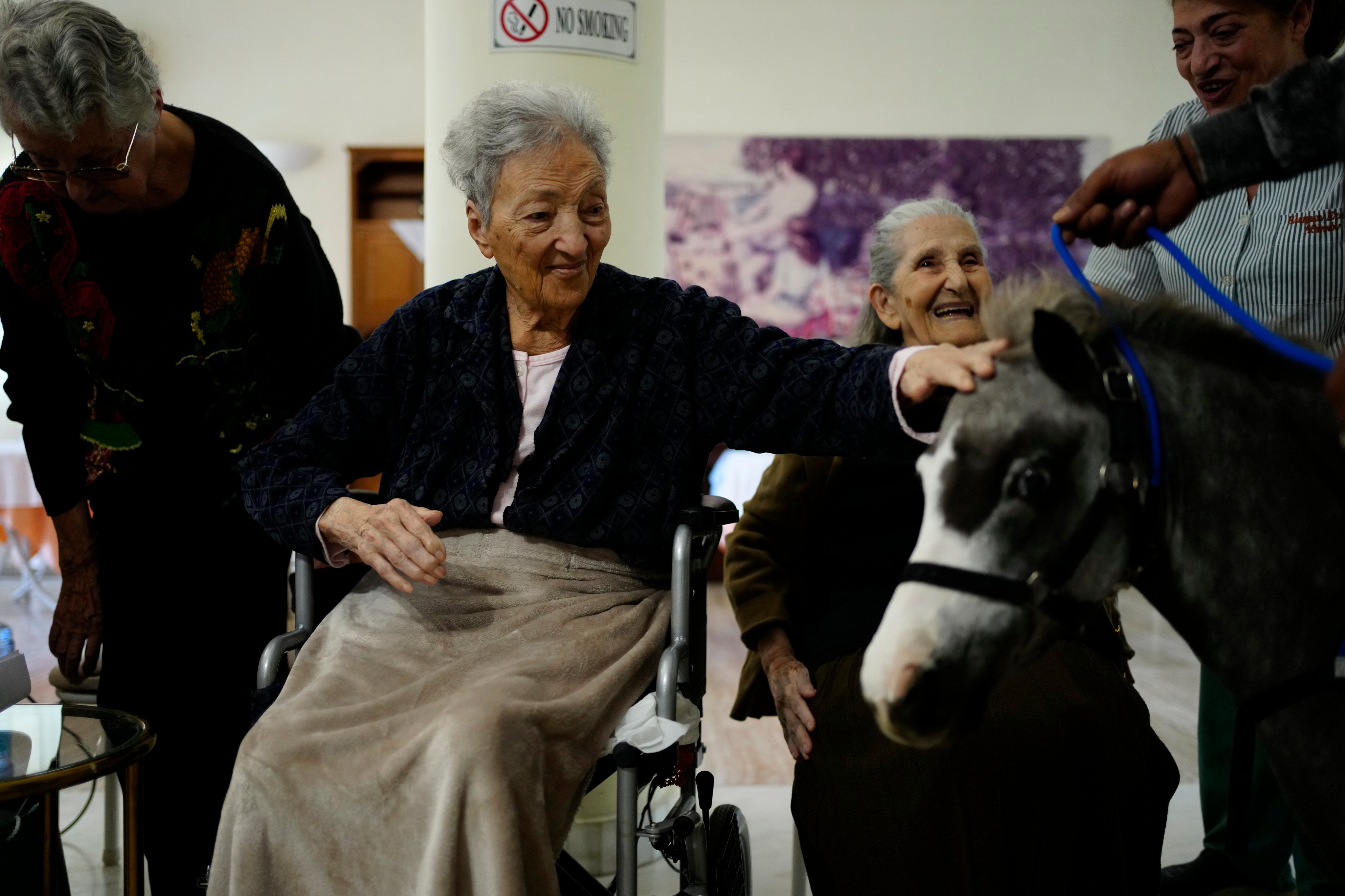 A resident of an old people’s home pats Calypso, a miniature horse used for therapy programmes, in Athens, Greece. Photo: AP